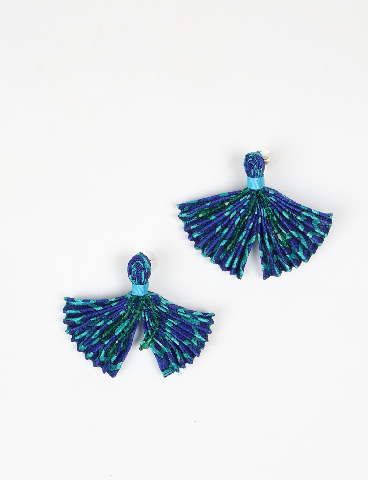 Blue and teal pleated fabric earrings with abstract pattern and beaded details, shown flat on white background
