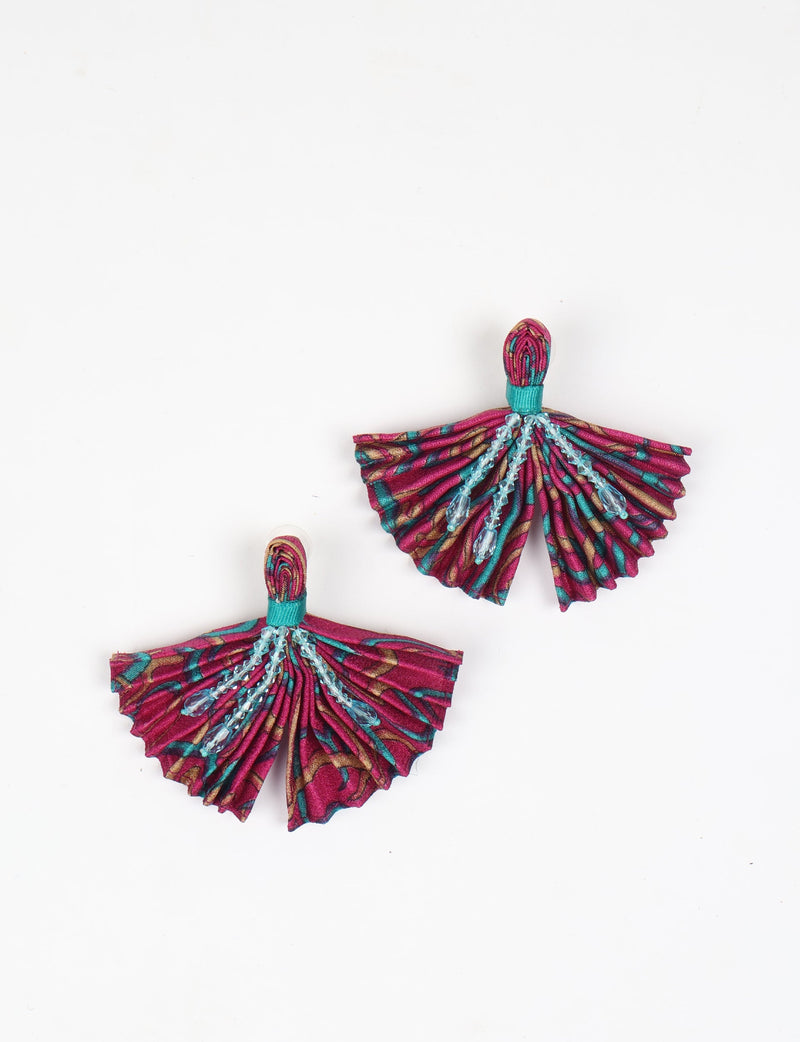 Pink abstract pleated fabric earrings with teal accents and hanging blue bead details, shown flat on white background