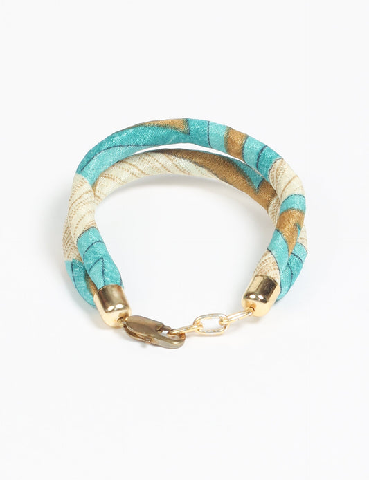 A close-up image of a hand wearing the Sari Rope bracelet, showcasing its colorful threads and unique design. This accessory embodies ethical fashion and sustainability, crafted from repurposed saris for a stylish and eco-conscious statement.