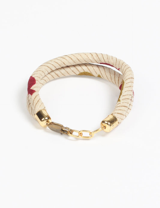 A close-up image of a hand wearing the Sari Rope bracelet, showcasing its colorful threads and unique design. This accessory embodies ethical fashion and sustainability, crafted from repurposed saris for a stylish and eco-conscious statement.