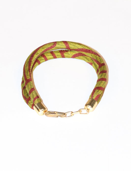 A close-up image of a hand wearing the Sari Rope bracelet, showcasing its colorful threads and unique design. This accessory embodies ethical fashion and sustainability, crafted from repurposed saris for a stylish and eco-conscious statement.