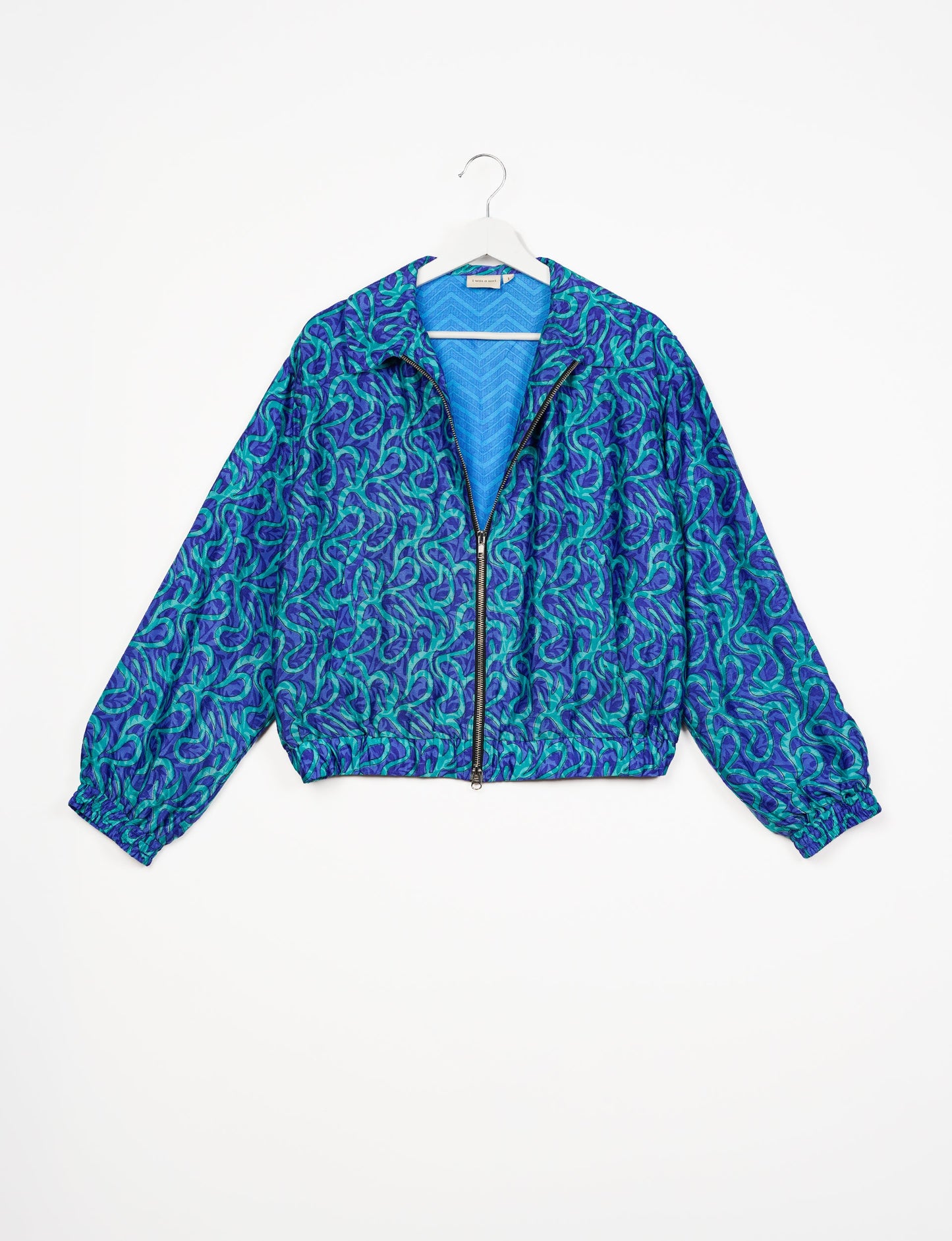 Stylish BOMBER JACKET, an upcycled clothing masterpiece with a cute cropped shape, elasticated details, and detachable metallic zipper. Contrast sari print lining adds a unique touch. Explore sustainable and eco-friendly fashion.