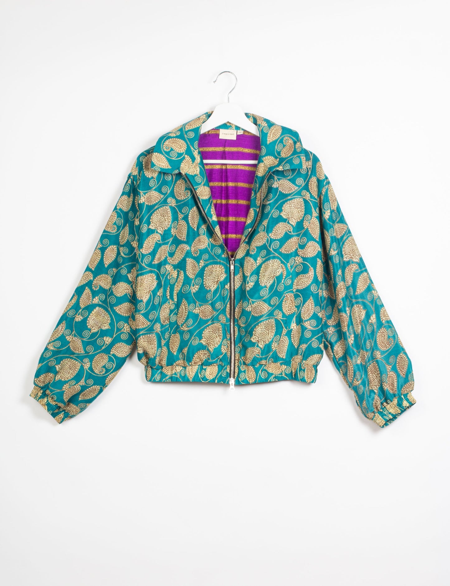 Stylish BOMBER JACKET, an upcycled clothing masterpiece with a cute cropped shape, elasticated details, and detachable metallic zipper. Contrast sari print lining adds a unique touch. Explore sustainable and eco-friendly fashion.