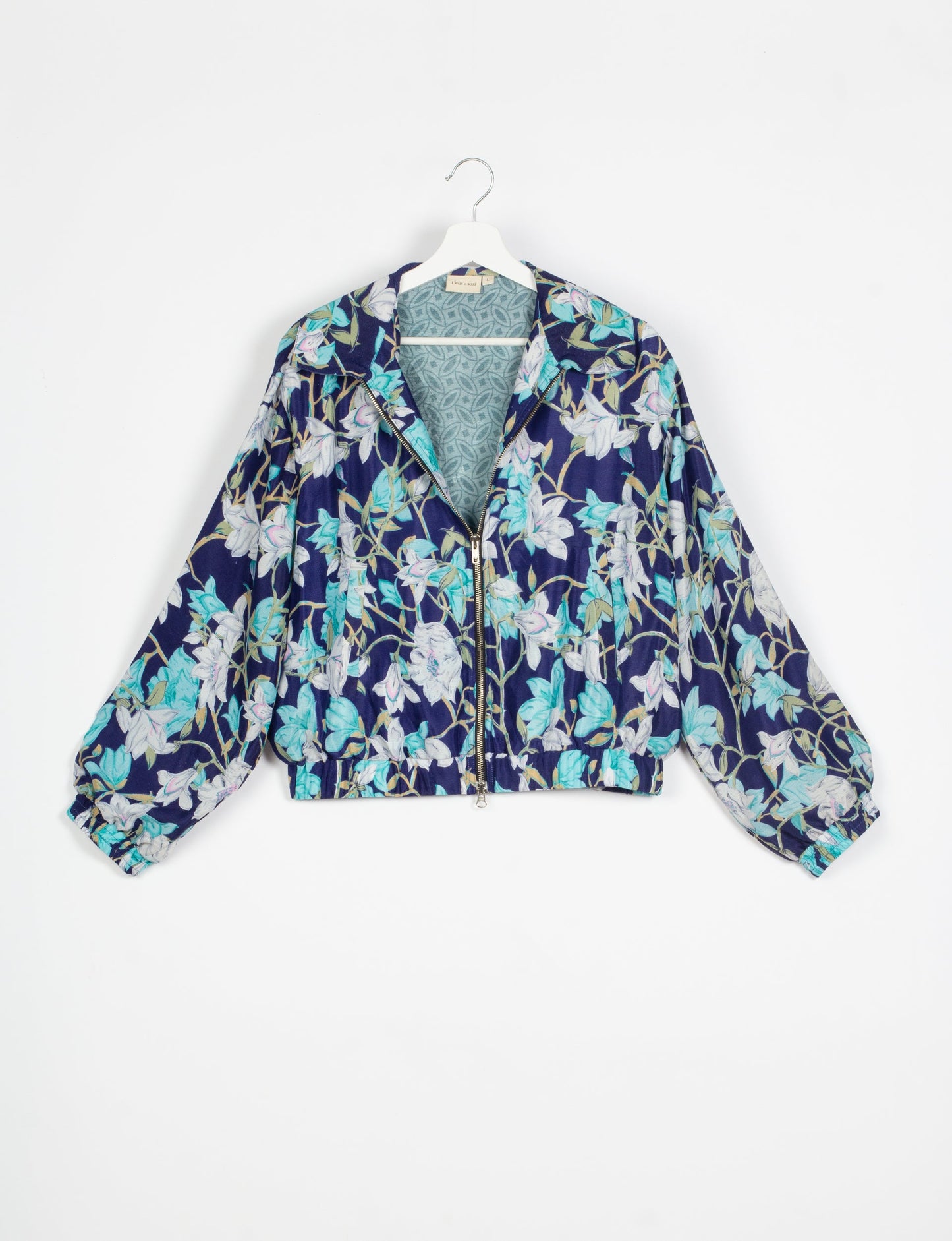 Stylish BOMBER JACKET, an upcycled clothing masterpiece with a cute cropped shape, elasticated details, and detachable metallic zipper. Contrast sari print lining adds a unique touch. Explore sustainable and eco-friendly fashion.