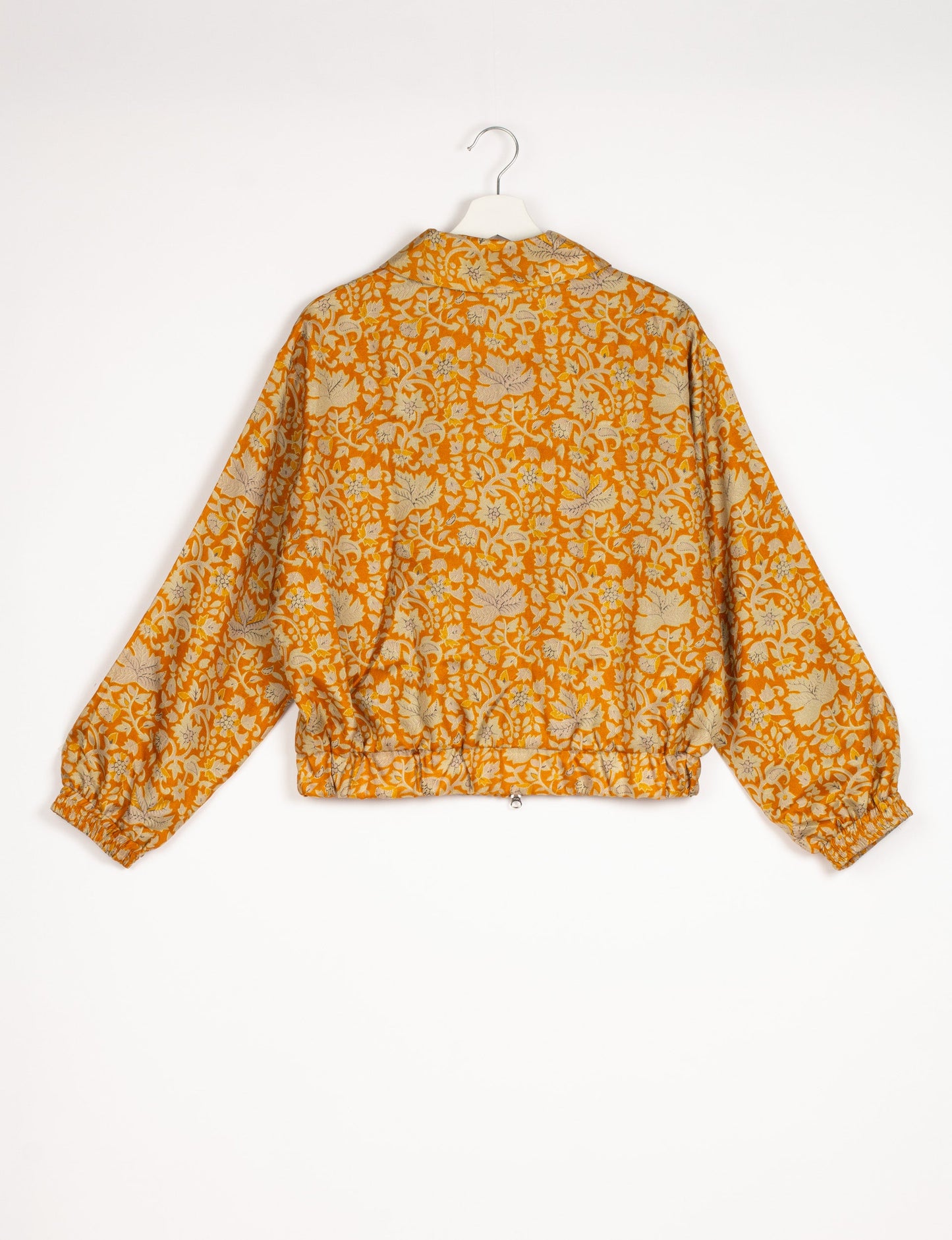 Stylish BOMBER JACKET, an upcycled clothing masterpiece with a cute cropped shape, elasticated details, and detachable metallic zipper. Contrast sari print lining adds a unique touch. Explore sustainable and eco-friendly fashion.