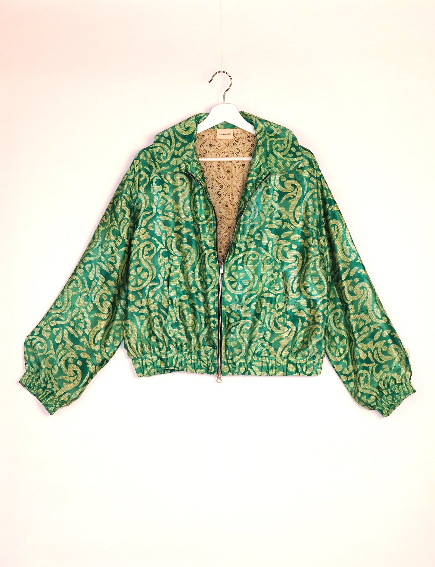 Stylish BOMBER JACKET, an upcycled clothing masterpiece with a cute cropped shape, elasticated details, and detachable metallic zipper. Contrast sari print lining adds a unique touch. Explore sustainable and eco-friendly fashion.