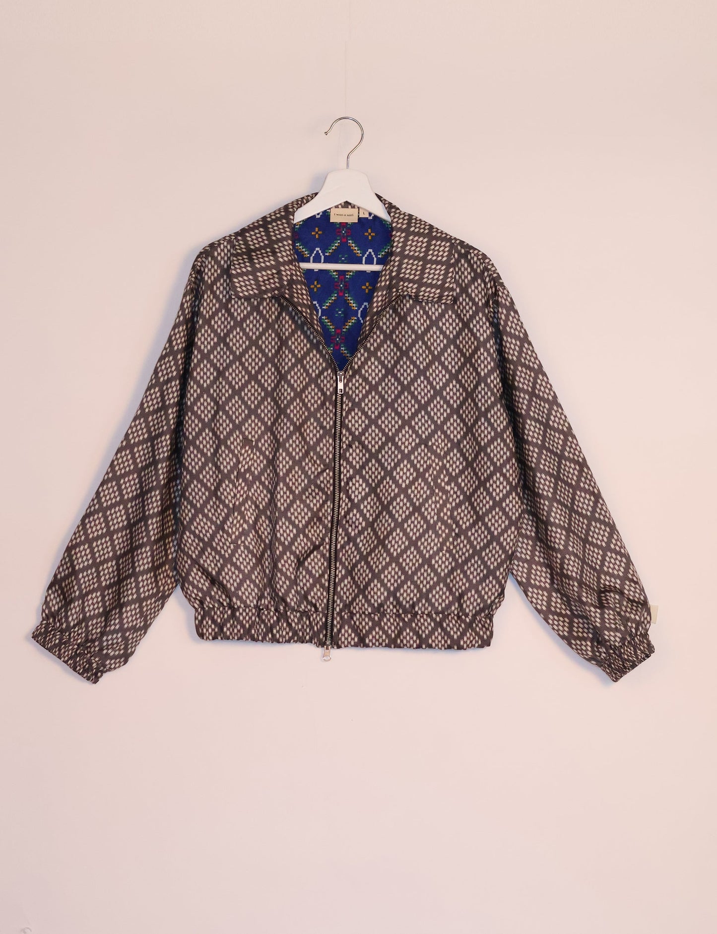 Stylish BOMBER JACKET, an upcycled clothing masterpiece with a cute cropped shape, elasticated details, and detachable metallic zipper. Contrast sari print lining adds a unique touch. Explore sustainable and eco-friendly fashion.