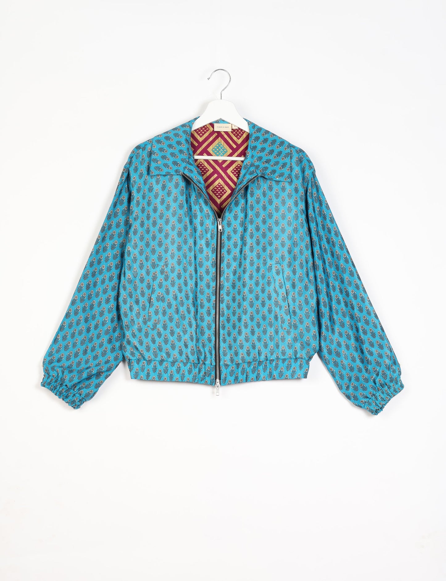 Stylish BOMBER JACKET, an upcycled clothing masterpiece with a cute cropped shape, elasticated details, and detachable metallic zipper. Contrast sari print lining adds a unique touch. Explore sustainable and eco-friendly fashion.