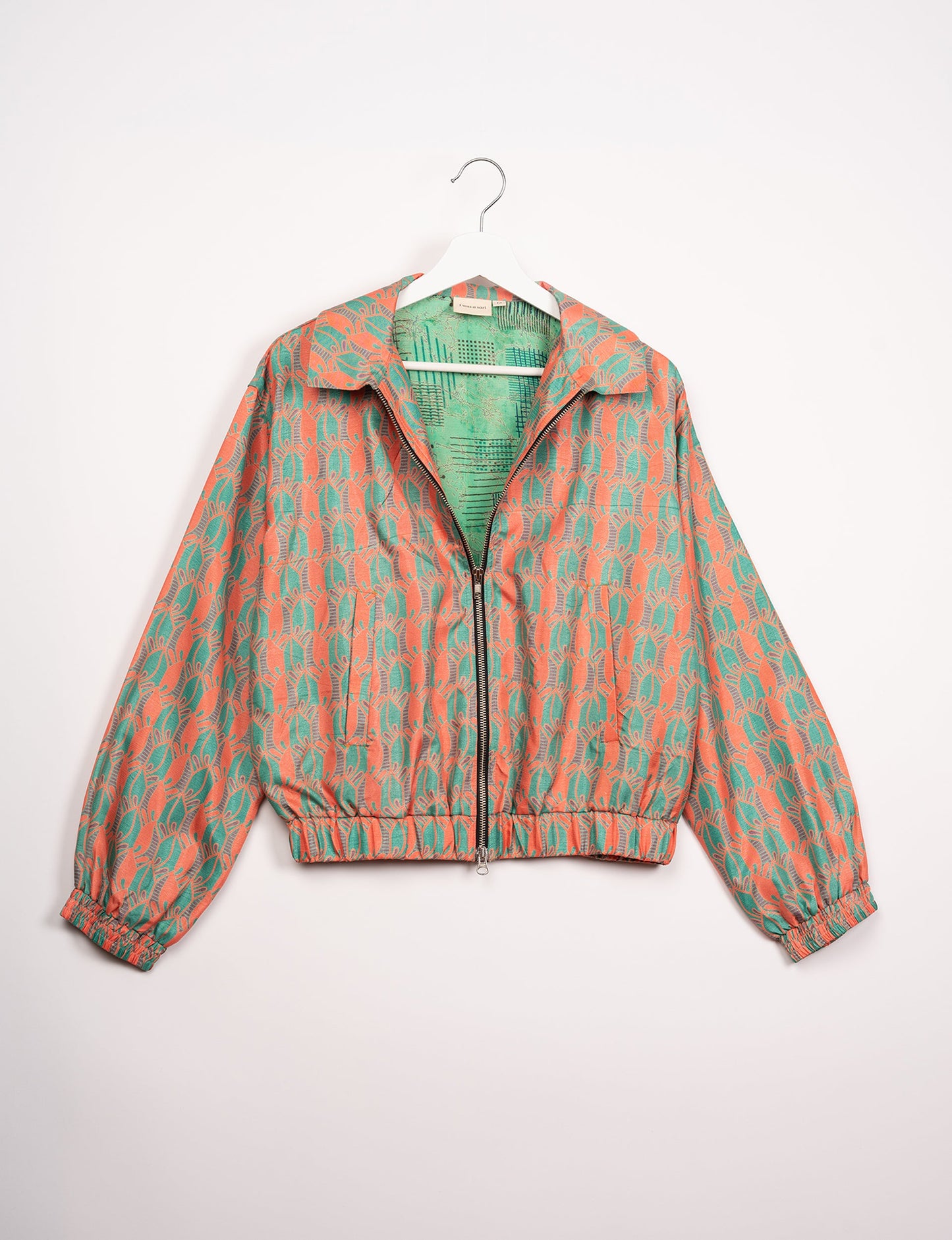 Stylish BOMBER JACKET, an upcycled clothing masterpiece with a cute cropped shape, elasticated details, and detachable metallic zipper. Contrast sari print lining adds a unique touch. Explore sustainable and eco-friendly fashion.