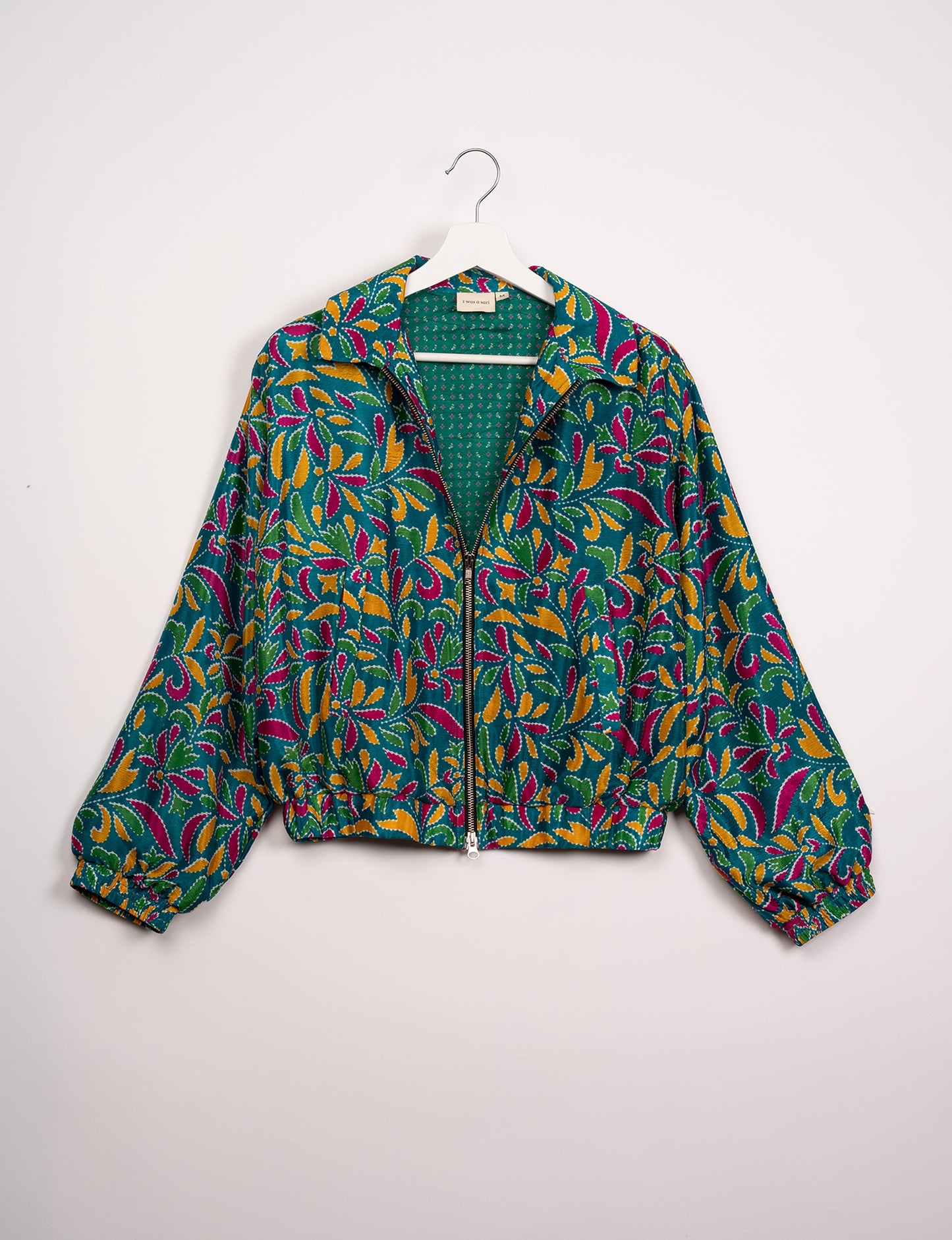 Stylish BOMBER JACKET, an upcycled clothing masterpiece with a cute cropped shape, elasticated details, and detachable metallic zipper. Contrast sari print lining adds a unique touch. Explore sustainable and eco-friendly fashion.