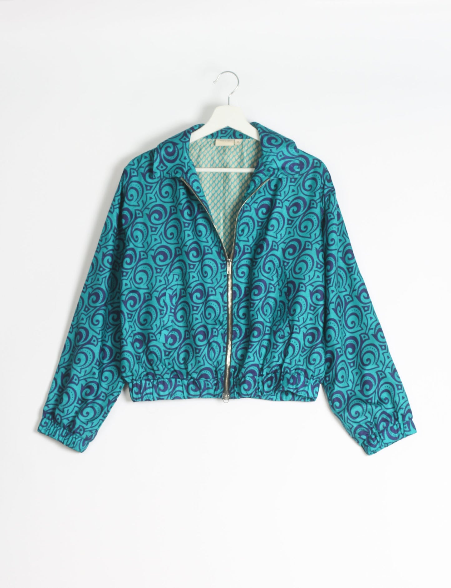 Stylish BOMBER JACKET, an upcycled clothing masterpiece with a cute cropped shape, elasticated details, and detachable metallic zipper. Contrast sari print lining adds a unique touch. Explore sustainable and eco-friendly fashion.