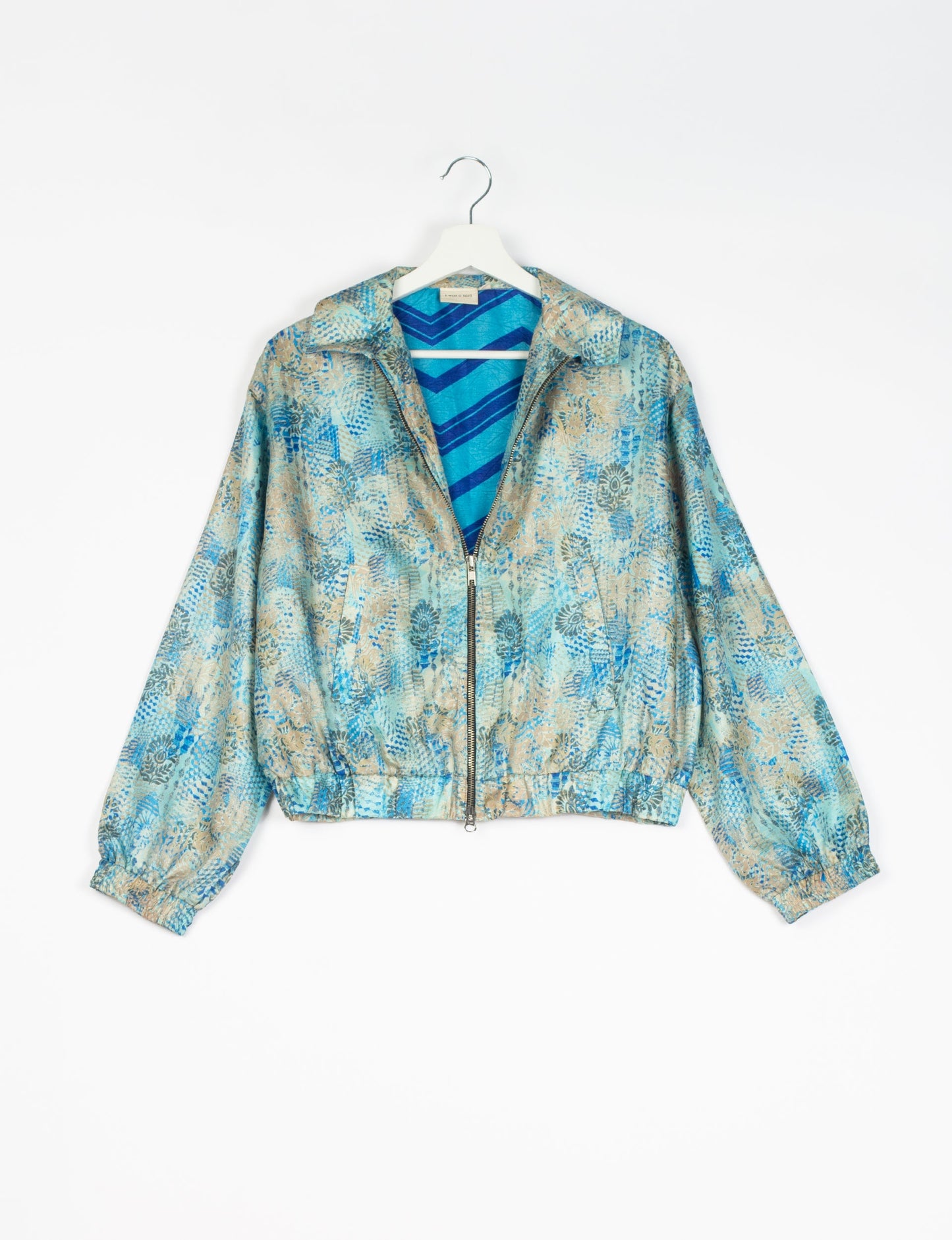 Stylish BOMBER JACKET, an upcycled clothing masterpiece with a cute cropped shape, elasticated details, and detachable metallic zipper. Contrast sari print lining adds a unique touch. Explore sustainable and eco-friendly fashion.