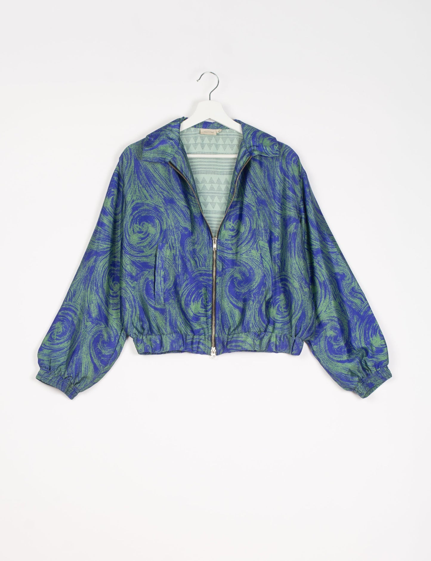 Stylish BOMBER JACKET, an upcycled clothing masterpiece with a cute cropped shape, elasticated details, and detachable metallic zipper. Contrast sari print lining adds a unique touch. Explore sustainable and eco-friendly fashion.