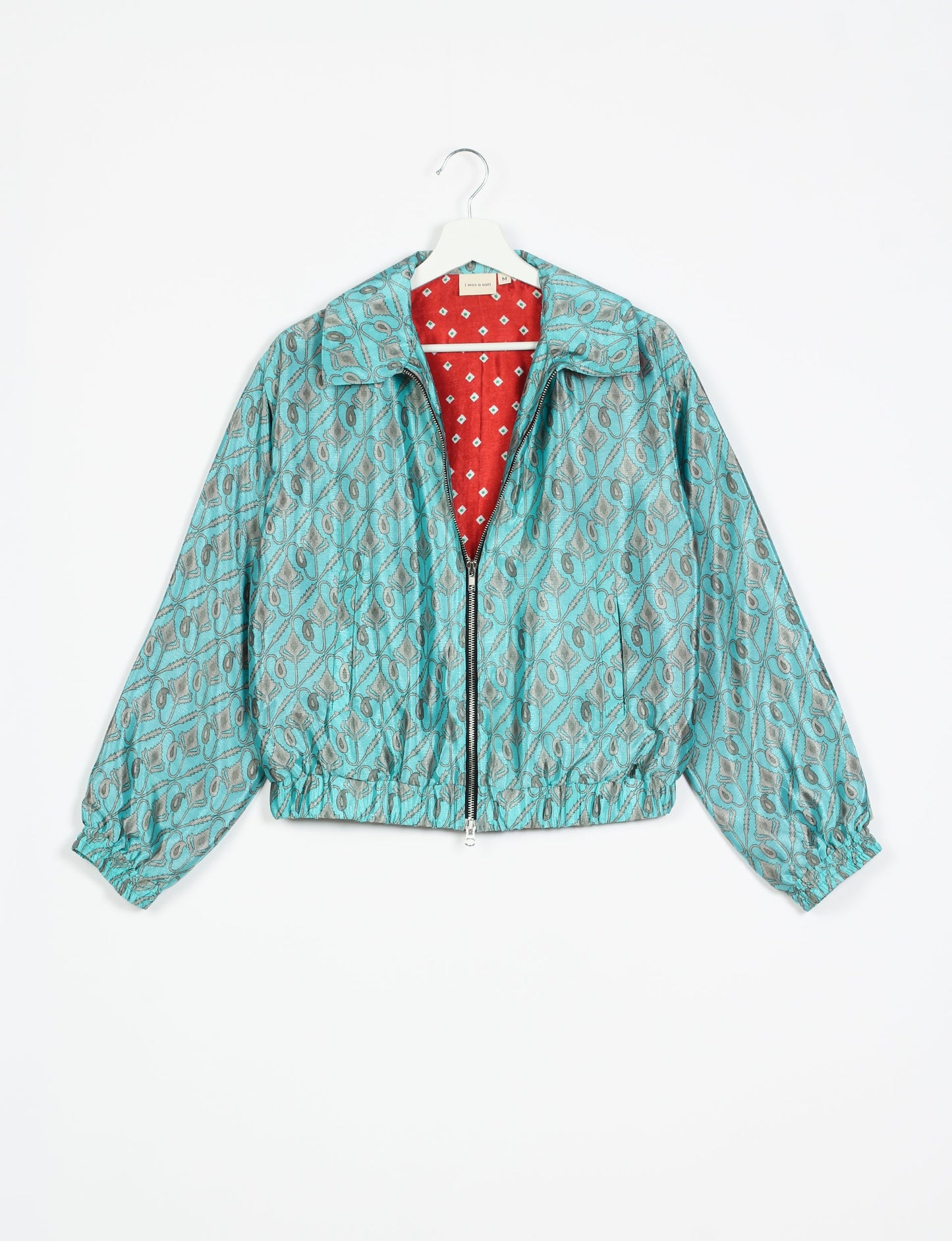 Stylish BOMBER JACKET, an upcycled clothing masterpiece with a cute cropped shape, elasticated details, and detachable metallic zipper. Contrast sari print lining adds a unique touch. Explore sustainable and eco-friendly fashion.