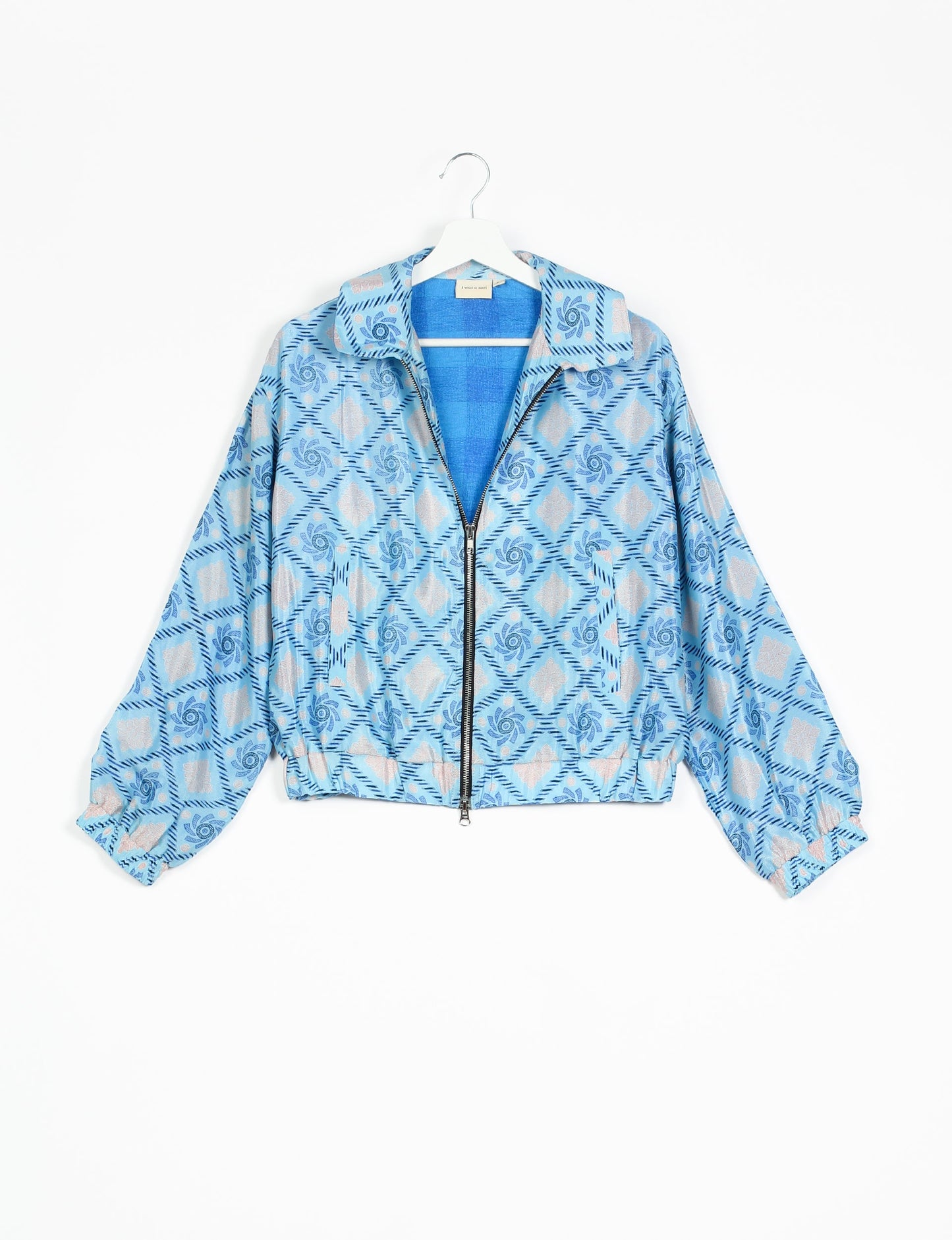 Stylish BOMBER JACKET, an upcycled clothing masterpiece with a cute cropped shape, elasticated details, and detachable metallic zipper. Contrast sari print lining adds a unique touch. Explore sustainable and eco-friendly fashion.