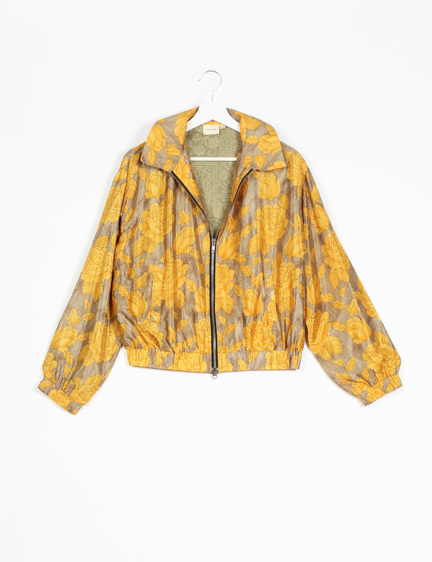 Stylish BOMBER JACKET, an upcycled clothing masterpiece with a cute cropped shape, elasticated details, and detachable metallic zipper. Contrast sari print lining adds a unique touch. Explore sustainable and eco-friendly fashion.