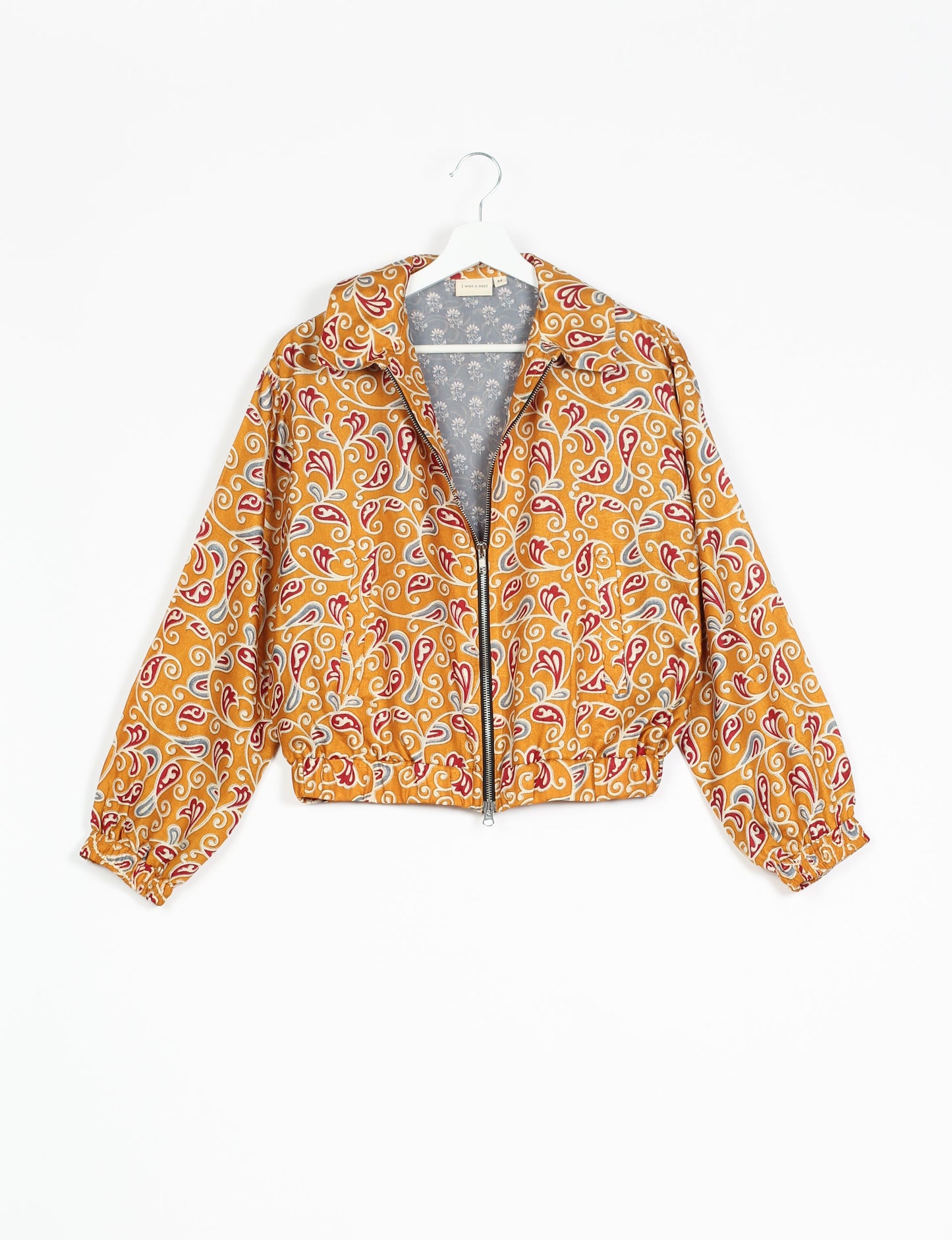 Stylish BOMBER JACKET, an upcycled clothing masterpiece with a cute cropped shape, elasticated details, and detachable metallic zipper. Contrast sari print lining adds a unique touch. Explore sustainable and eco-friendly fashion.