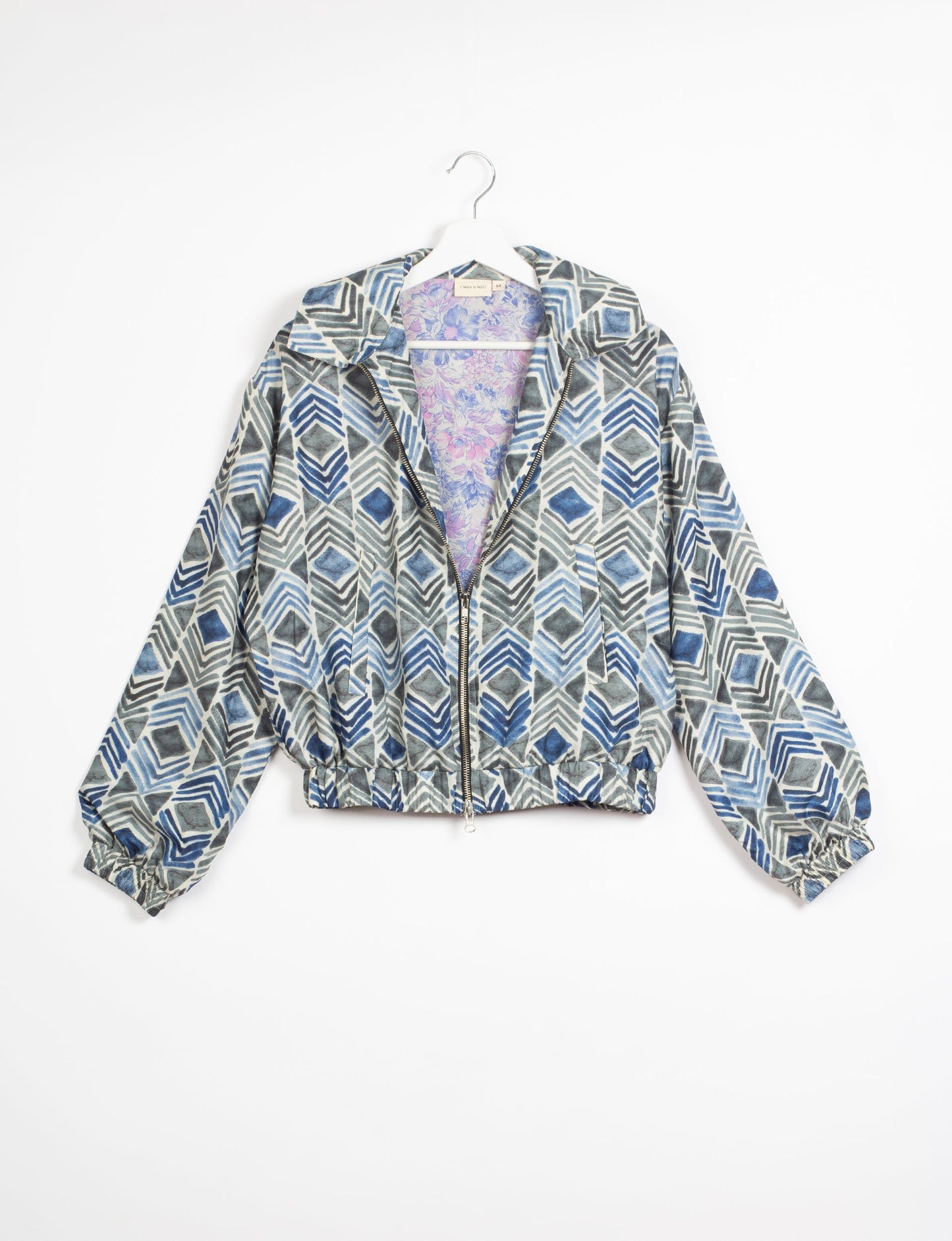 Stylish BOMBER JACKET, an upcycled clothing masterpiece with a cute cropped shape, elasticated details, and detachable metallic zipper. Contrast sari print lining adds a unique touch. Explore sustainable and eco-friendly fashion.