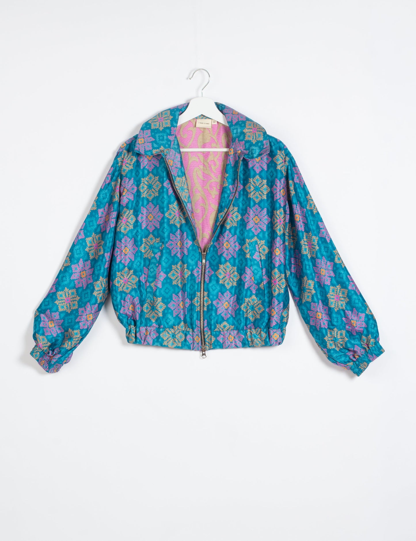 Stylish BOMBER JACKET, an upcycled clothing masterpiece with a cute cropped shape, elasticated details, and detachable metallic zipper. Contrast sari print lining adds a unique touch. Explore sustainable and eco-friendly fashion.