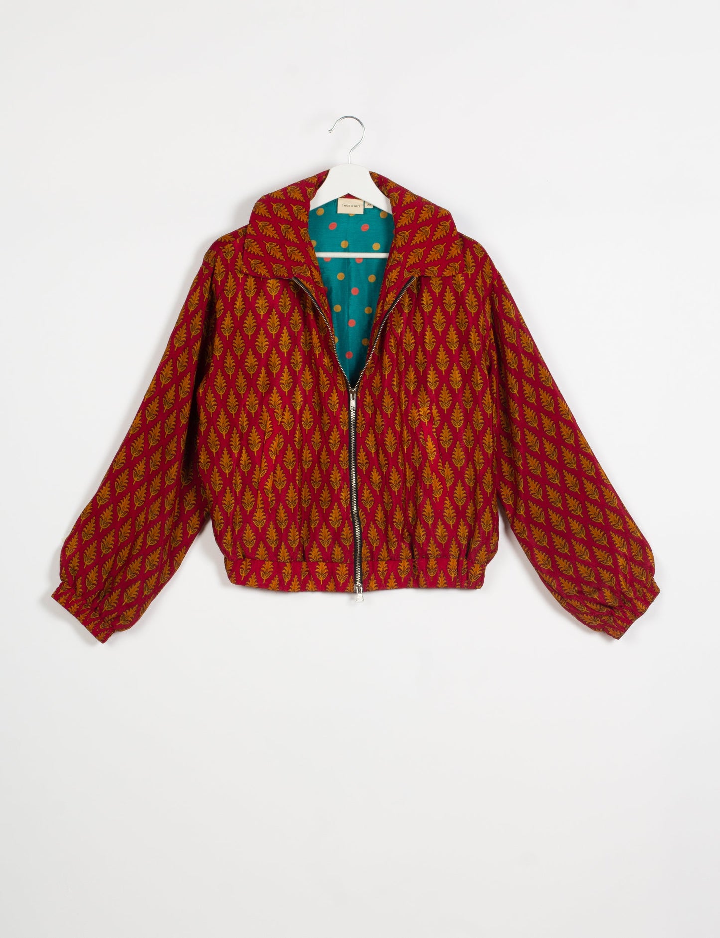 Stylish BOMBER JACKET, an upcycled clothing masterpiece with a cute cropped shape, elasticated details, and detachable metallic zipper. Contrast sari print lining adds a unique touch. Explore sustainable and eco-friendly fashion.