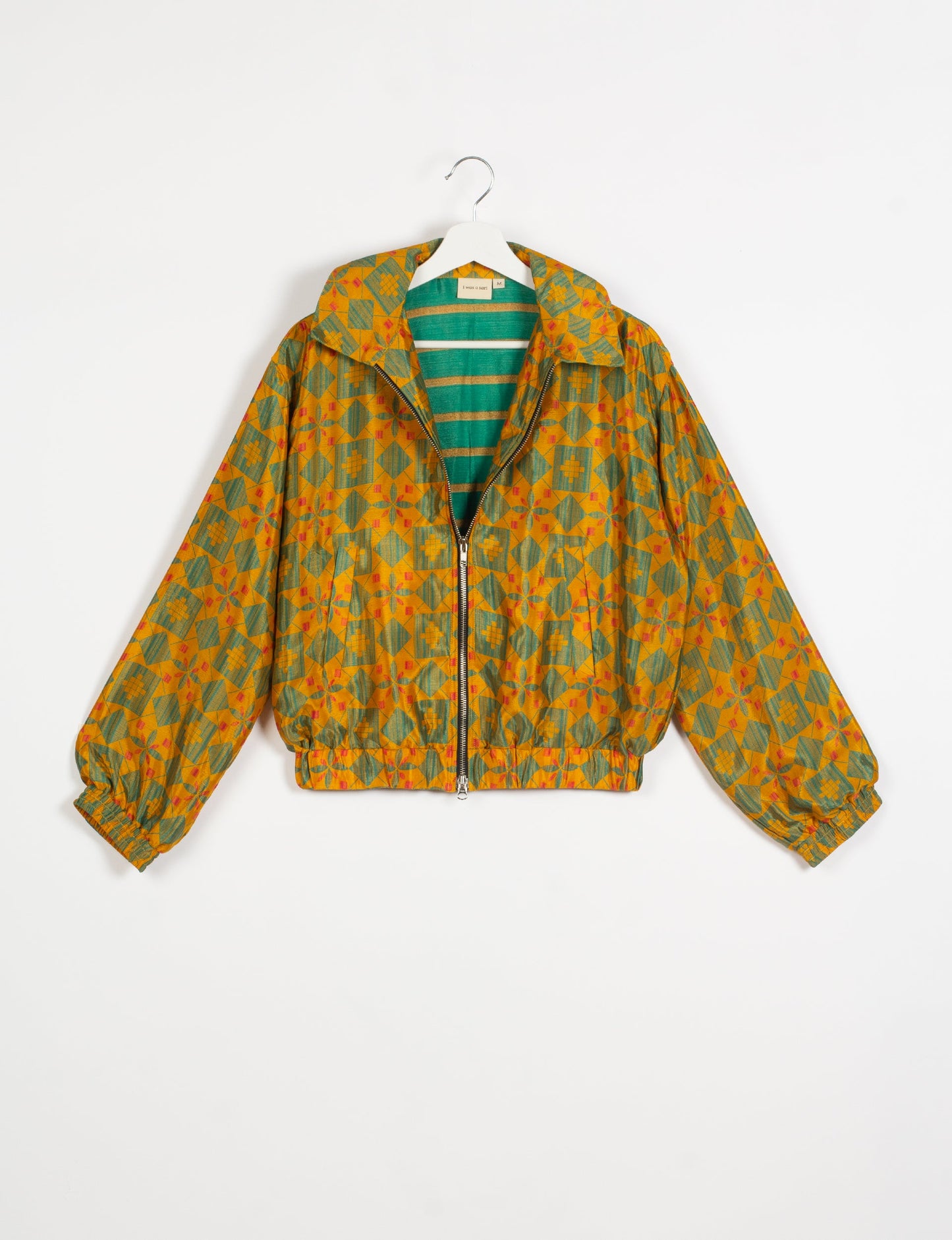 Stylish BOMBER JACKET, an upcycled clothing masterpiece with a cute cropped shape, elasticated details, and detachable metallic zipper. Contrast sari print lining adds a unique touch. Explore sustainable and eco-friendly fashion.