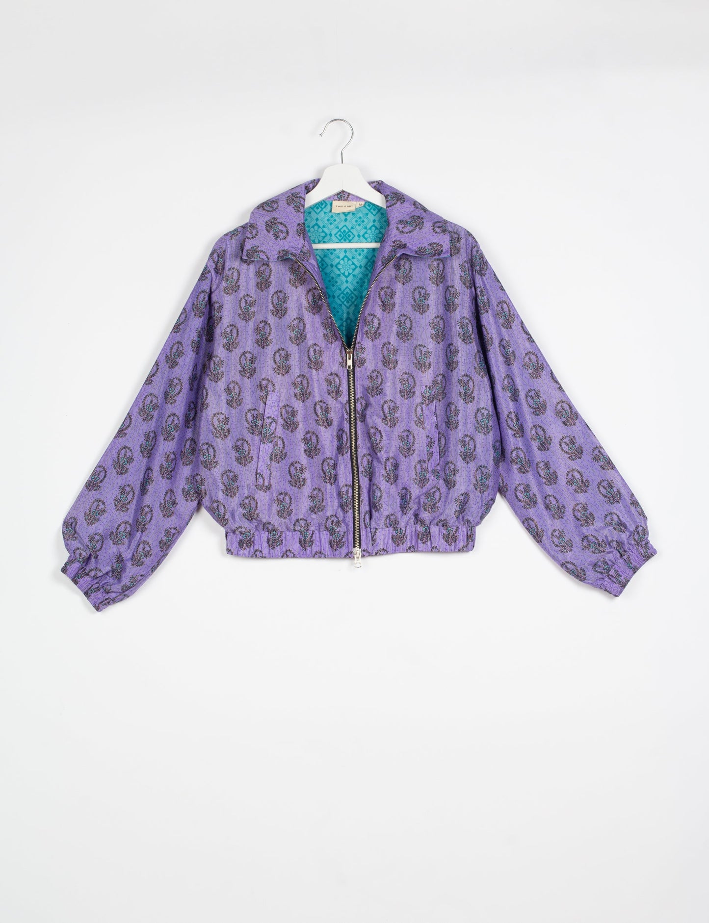 Stylish BOMBER JACKET, an upcycled clothing masterpiece with a cute cropped shape, elasticated details, and detachable metallic zipper. Contrast sari print lining adds a unique touch. Explore sustainable and eco-friendly fashion.