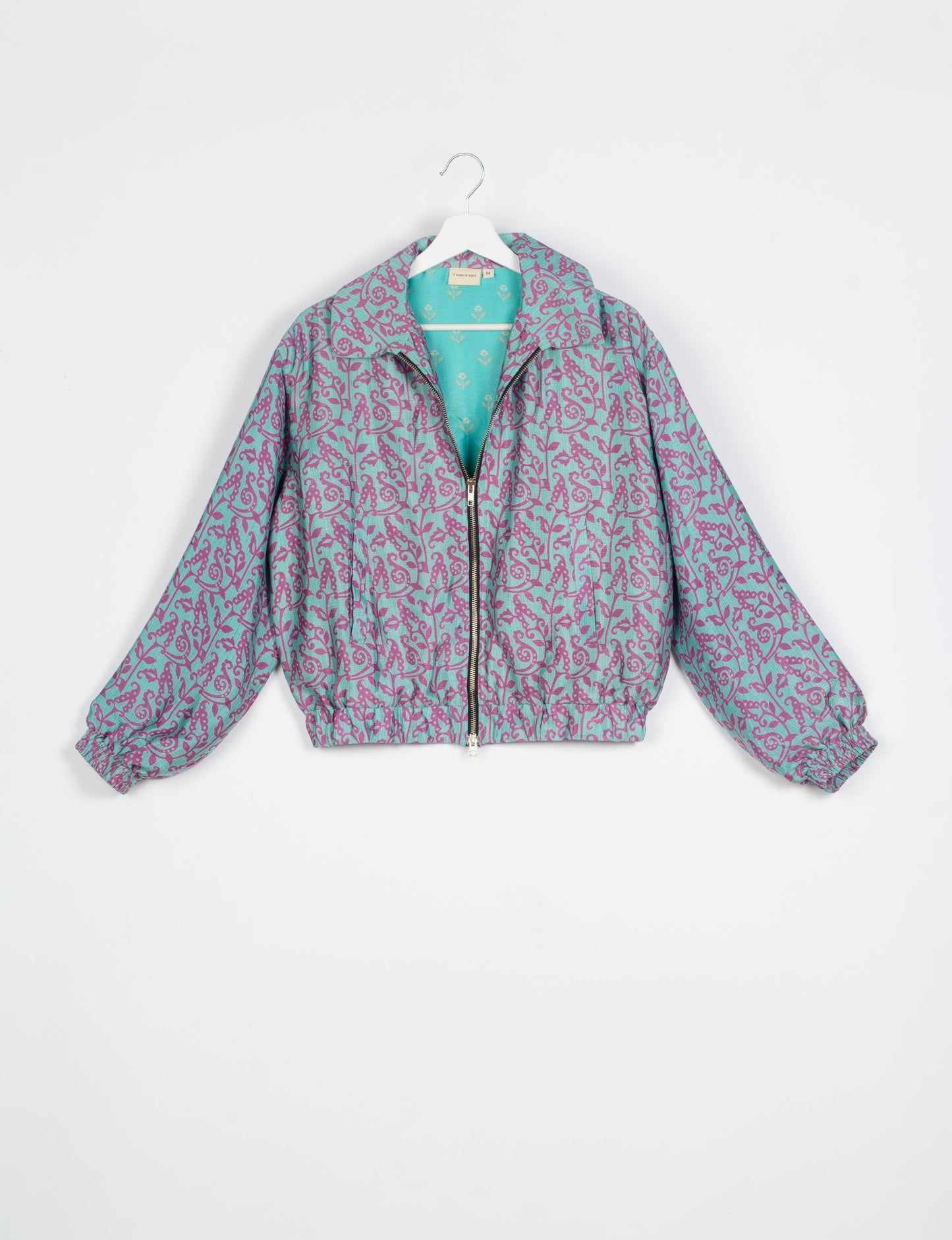 Stylish BOMBER JACKET, an upcycled clothing masterpiece with a cute cropped shape, elasticated details, and detachable metallic zipper. Contrast sari print lining adds a unique touch. Explore sustainable and eco-friendly fashion.