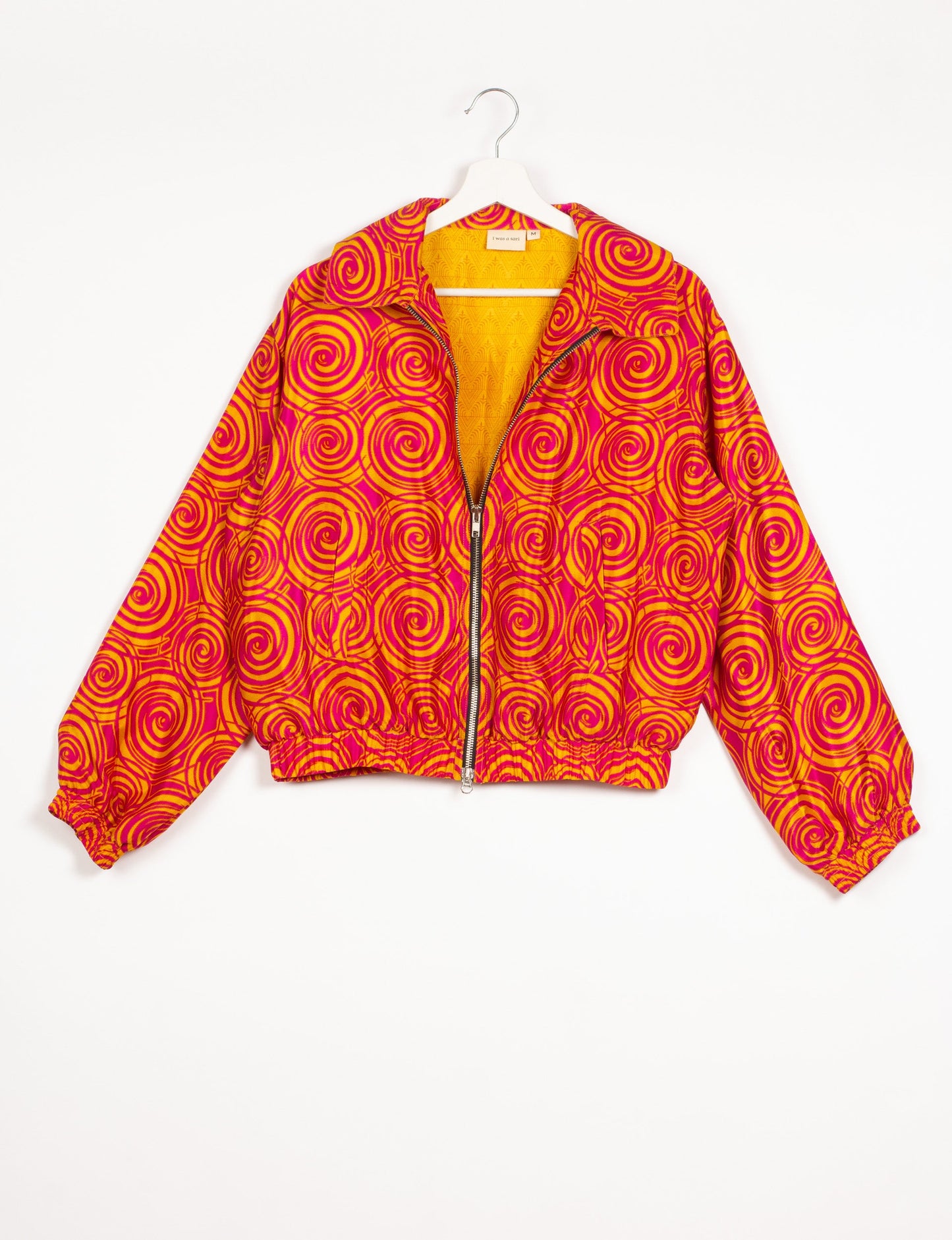 Stylish BOMBER JACKET, an upcycled clothing masterpiece with a cute cropped shape, elasticated details, and detachable metallic zipper. Contrast sari print lining adds a unique touch. Explore sustainable and eco-friendly fashion.