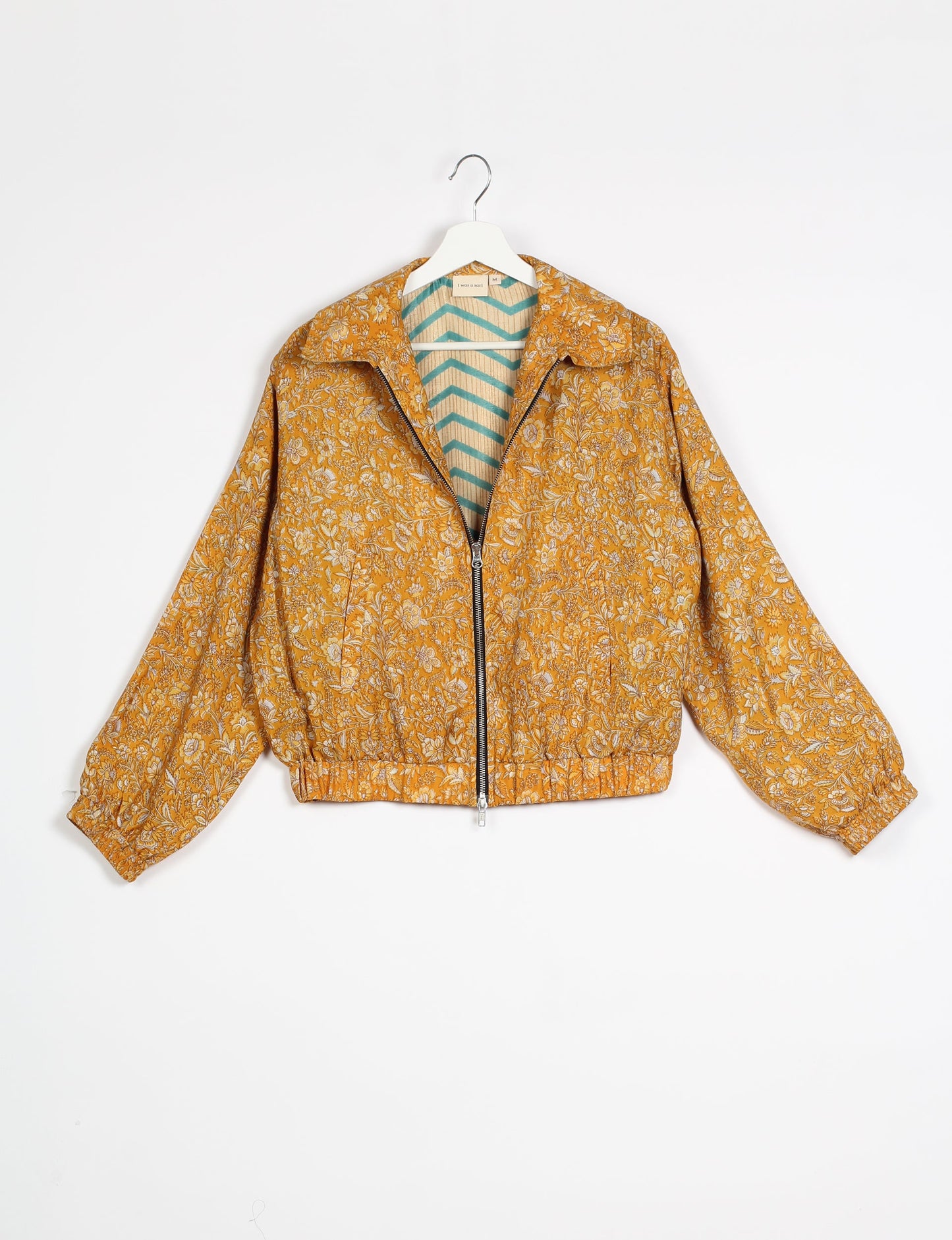 Stylish BOMBER JACKET, an upcycled clothing masterpiece with a cute cropped shape, elasticated details, and detachable metallic zipper. Contrast sari print lining adds a unique touch. Explore sustainable and eco-friendly fashion.