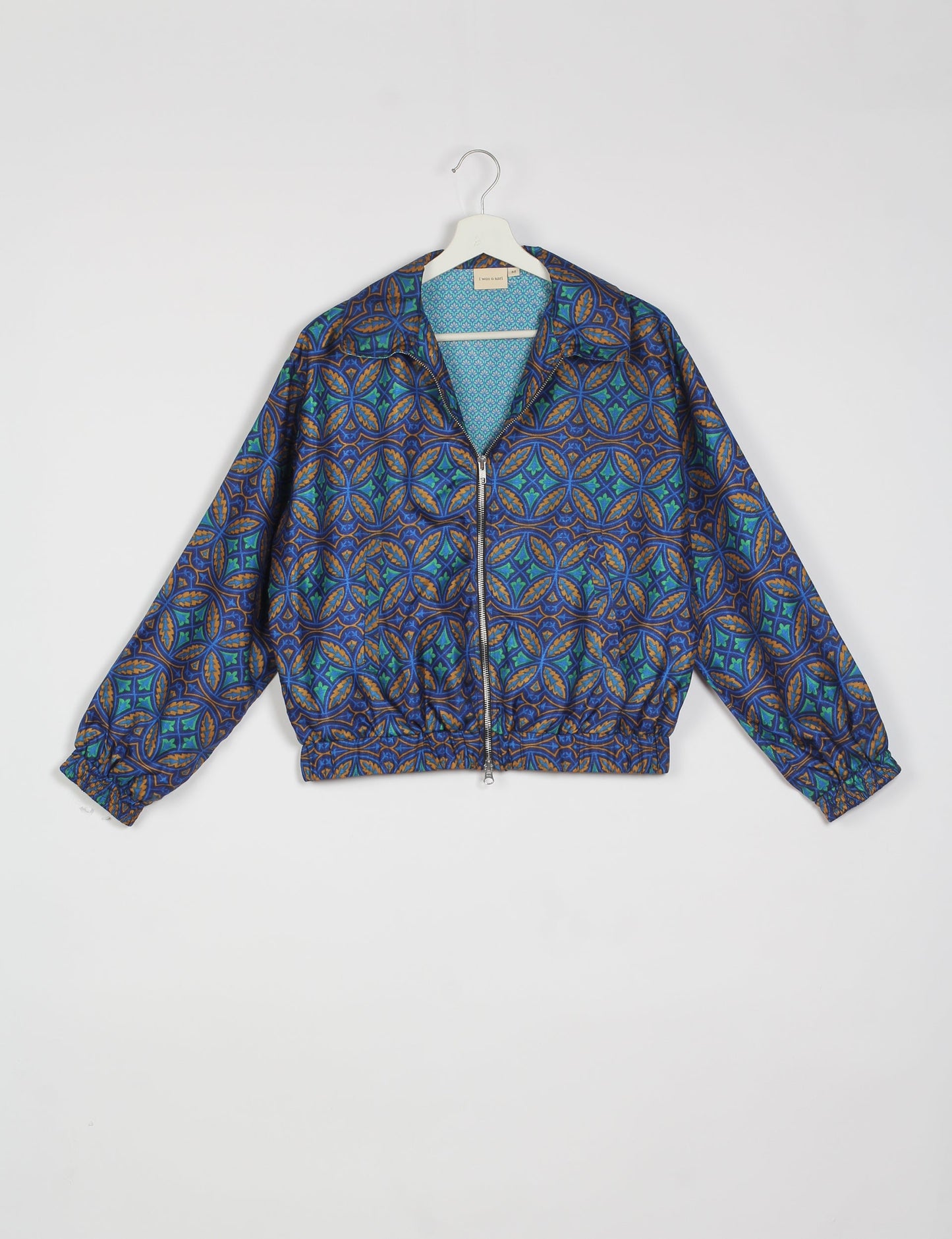 Stylish BOMBER JACKET, an upcycled clothing masterpiece with a cute cropped shape, elasticated details, and detachable metallic zipper. Contrast sari print lining adds a unique touch. Explore sustainable and eco-friendly fashion.