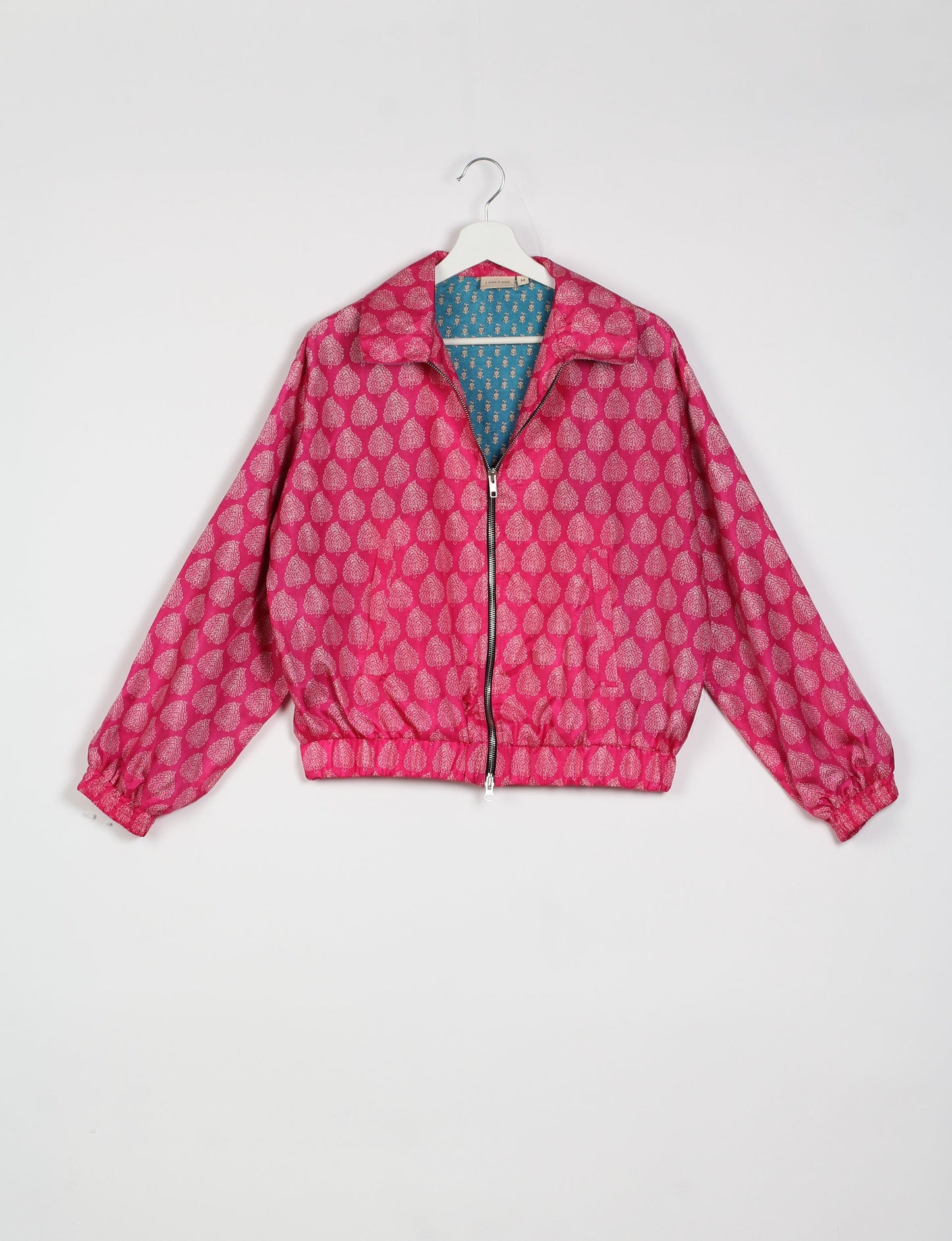 Stylish BOMBER JACKET, an upcycled clothing masterpiece with a cute cropped shape, elasticated details, and detachable metallic zipper. Contrast sari print lining adds a unique touch. Explore sustainable and eco-friendly fashion.