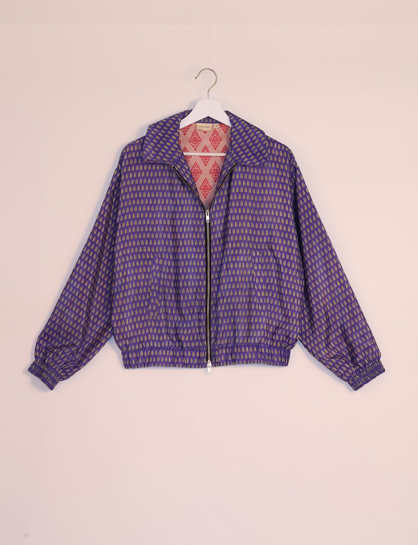 Stylish BOMBER JACKET, an upcycled clothing masterpiece with a cute cropped shape, elasticated details, and detachable metallic zipper. Contrast sari print lining adds a unique touch. Explore sustainable and eco-friendly fashion.