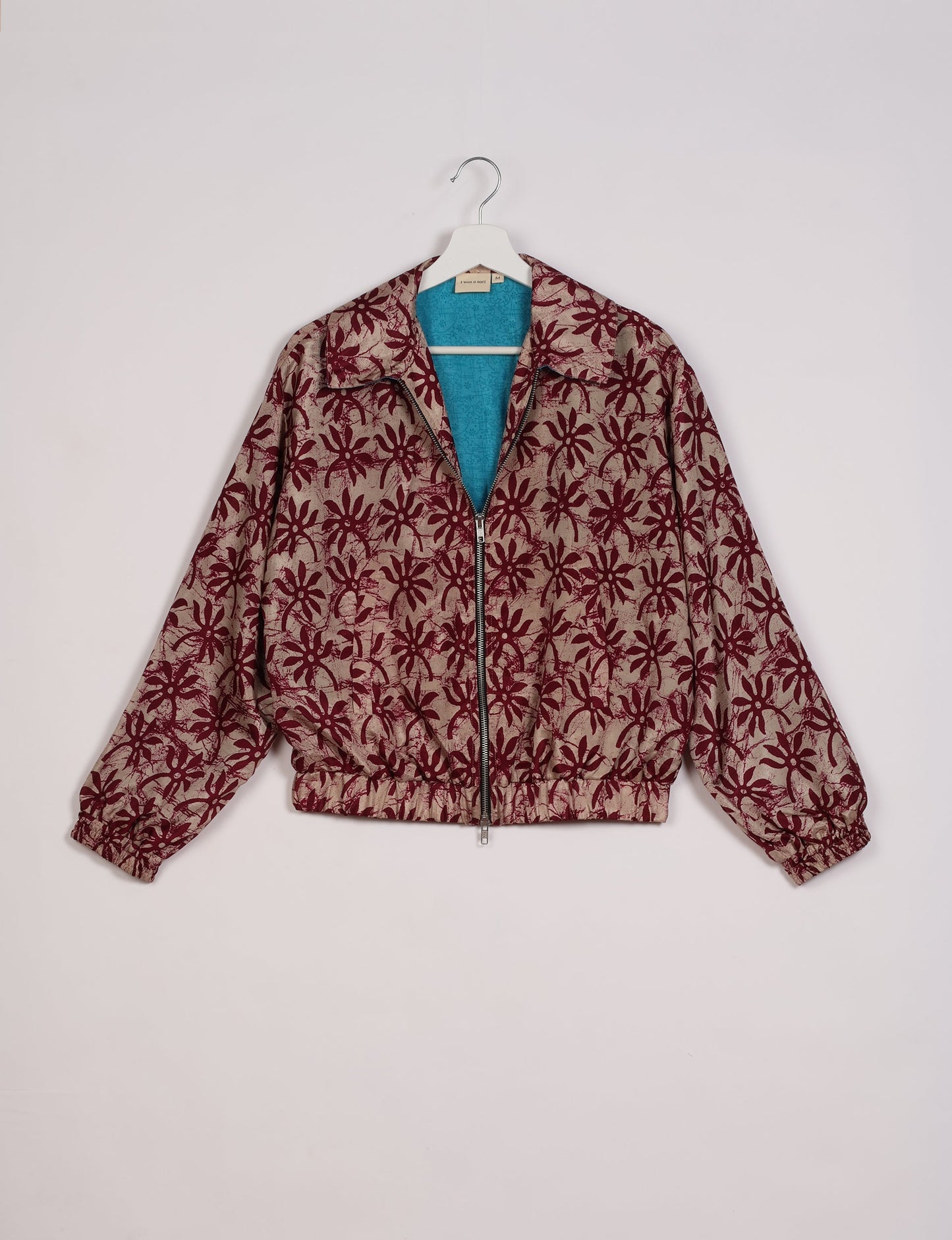 Stylish BOMBER JACKET, an upcycled clothing masterpiece with a cute cropped shape, elasticated details, and detachable metallic zipper. Contrast sari print lining adds a unique touch. Explore sustainable and eco-friendly fashion.