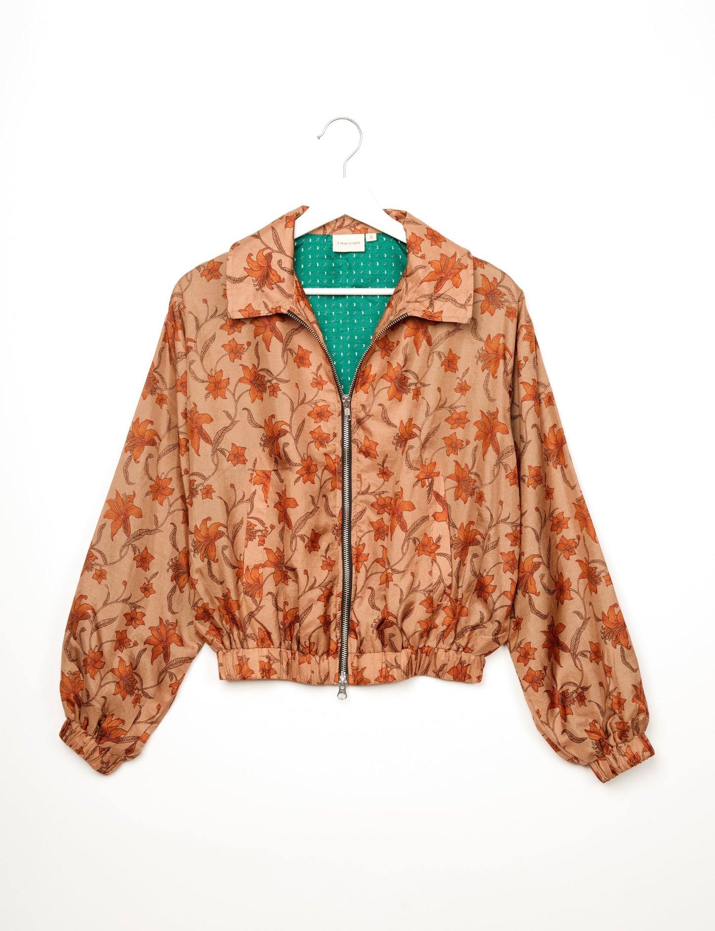 Stylish BOMBER JACKET, an upcycled clothing masterpiece with a cute cropped shape, elasticated details, and detachable metallic zipper. Contrast sari print lining adds a unique touch. Explore sustainable and eco-friendly fashion.