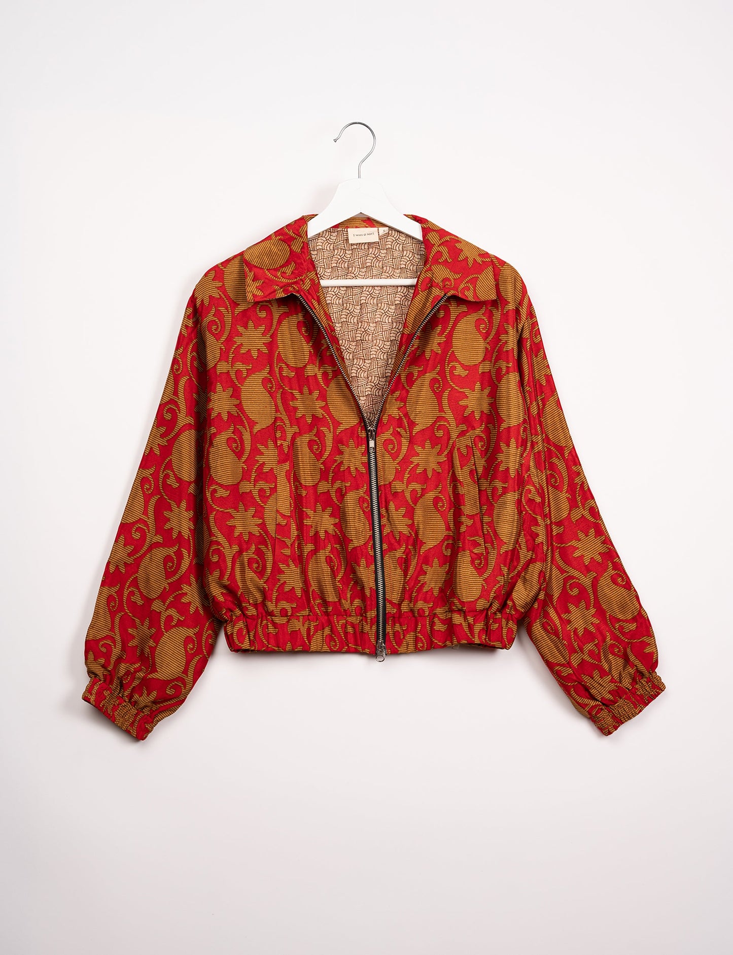 Stylish BOMBER JACKET, an upcycled clothing masterpiece with a cute cropped shape, elasticated details, and detachable metallic zipper. Contrast sari print lining adds a unique touch. Explore sustainable and eco-friendly fashion.