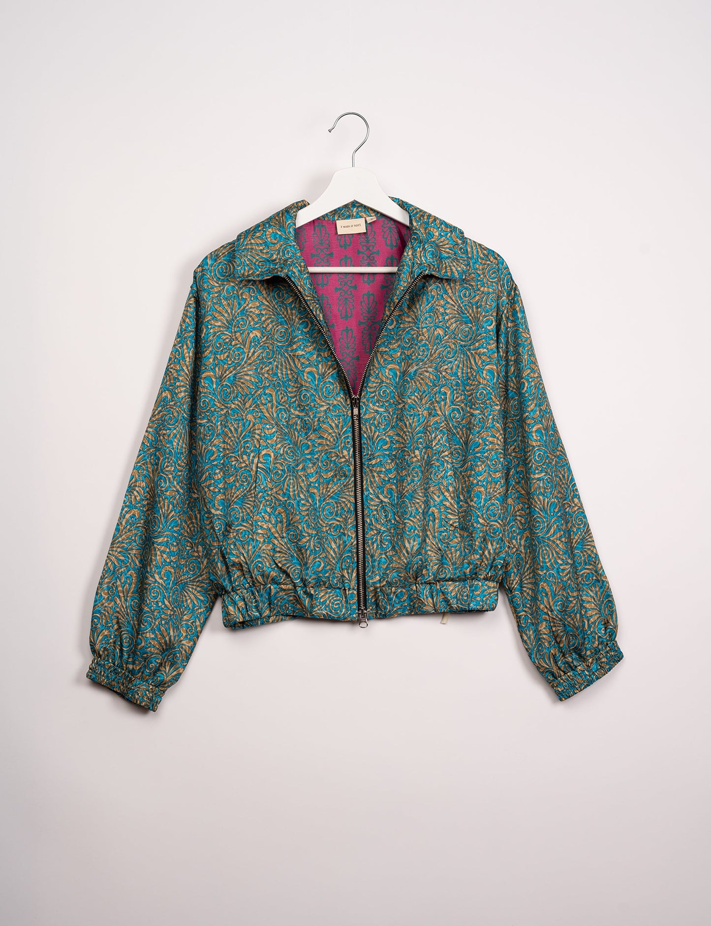 Stylish BOMBER JACKET, an upcycled clothing masterpiece with a cute cropped shape, elasticated details, and detachable metallic zipper. Contrast sari print lining adds a unique touch. Explore sustainable and eco-friendly fashion.