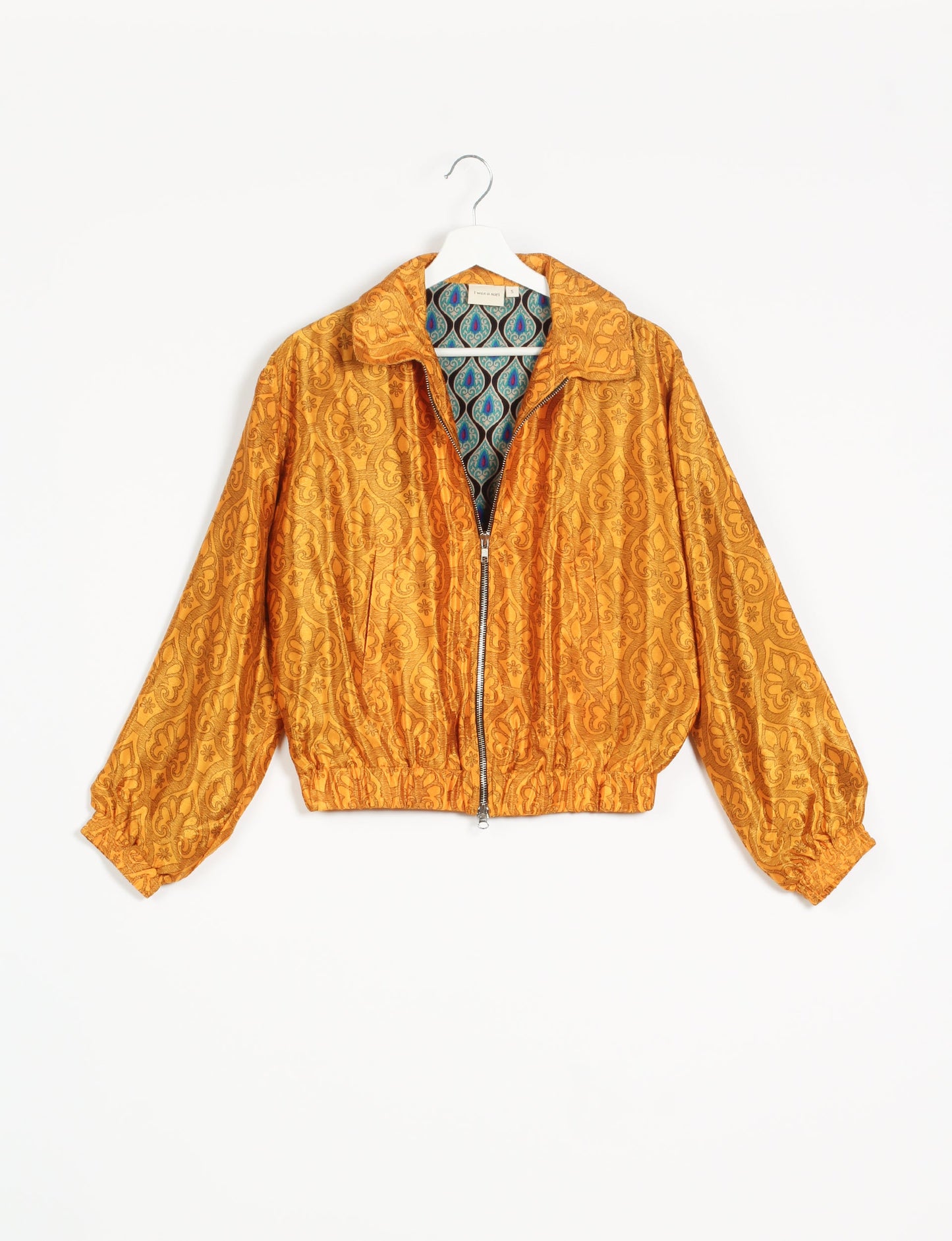 Stylish BOMBER JACKET, an upcycled clothing masterpiece with a cute cropped shape, elasticated details, and detachable metallic zipper. Contrast sari print lining adds a unique touch. Explore sustainable and eco-friendly fashion.