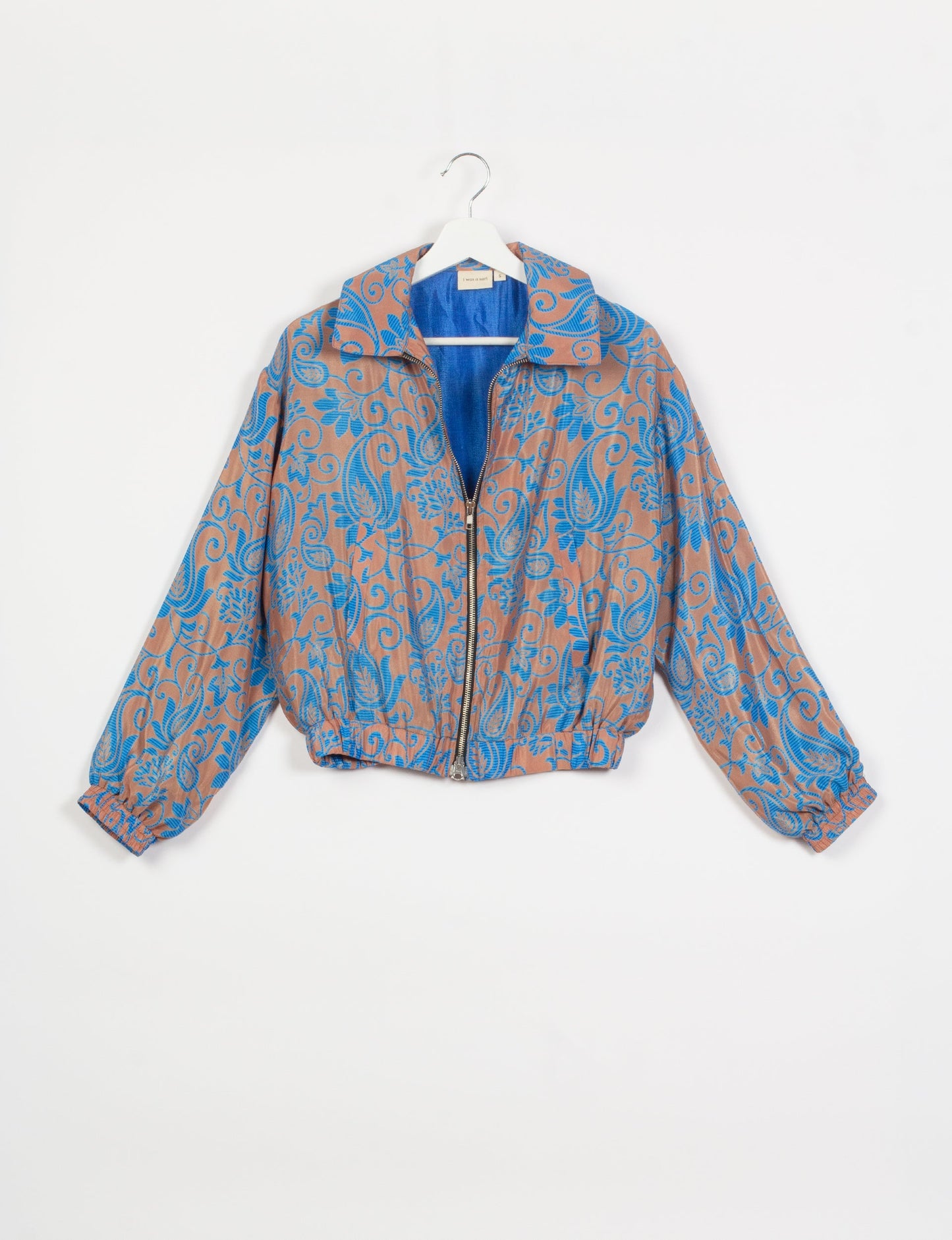 Stylish BOMBER JACKET, an upcycled clothing masterpiece with a cute cropped shape, elasticated details, and detachable metallic zipper. Contrast sari print lining adds a unique touch. Explore sustainable and eco-friendly fashion.