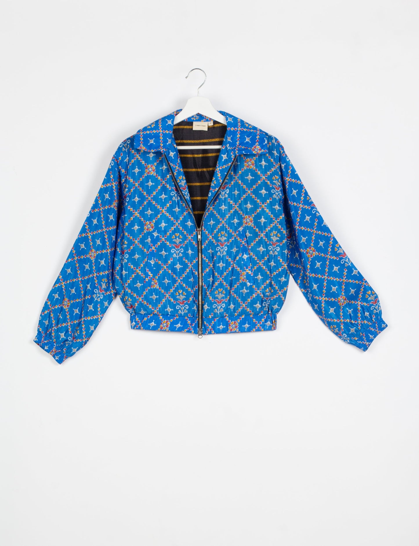 Stylish BOMBER JACKET, an upcycled clothing masterpiece with a cute cropped shape, elasticated details, and detachable metallic zipper. Contrast sari print lining adds a unique touch. Explore sustainable and eco-friendly fashion.