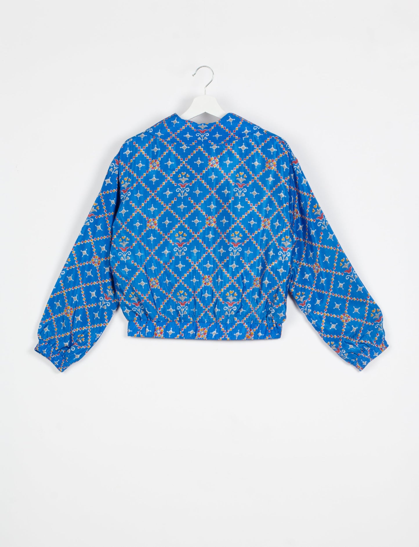 Stylish BOMBER JACKET, an upcycled clothing masterpiece with a cute cropped shape, elasticated details, and detachable metallic zipper. Contrast sari print lining adds a unique touch. Explore sustainable and eco-friendly fashion.