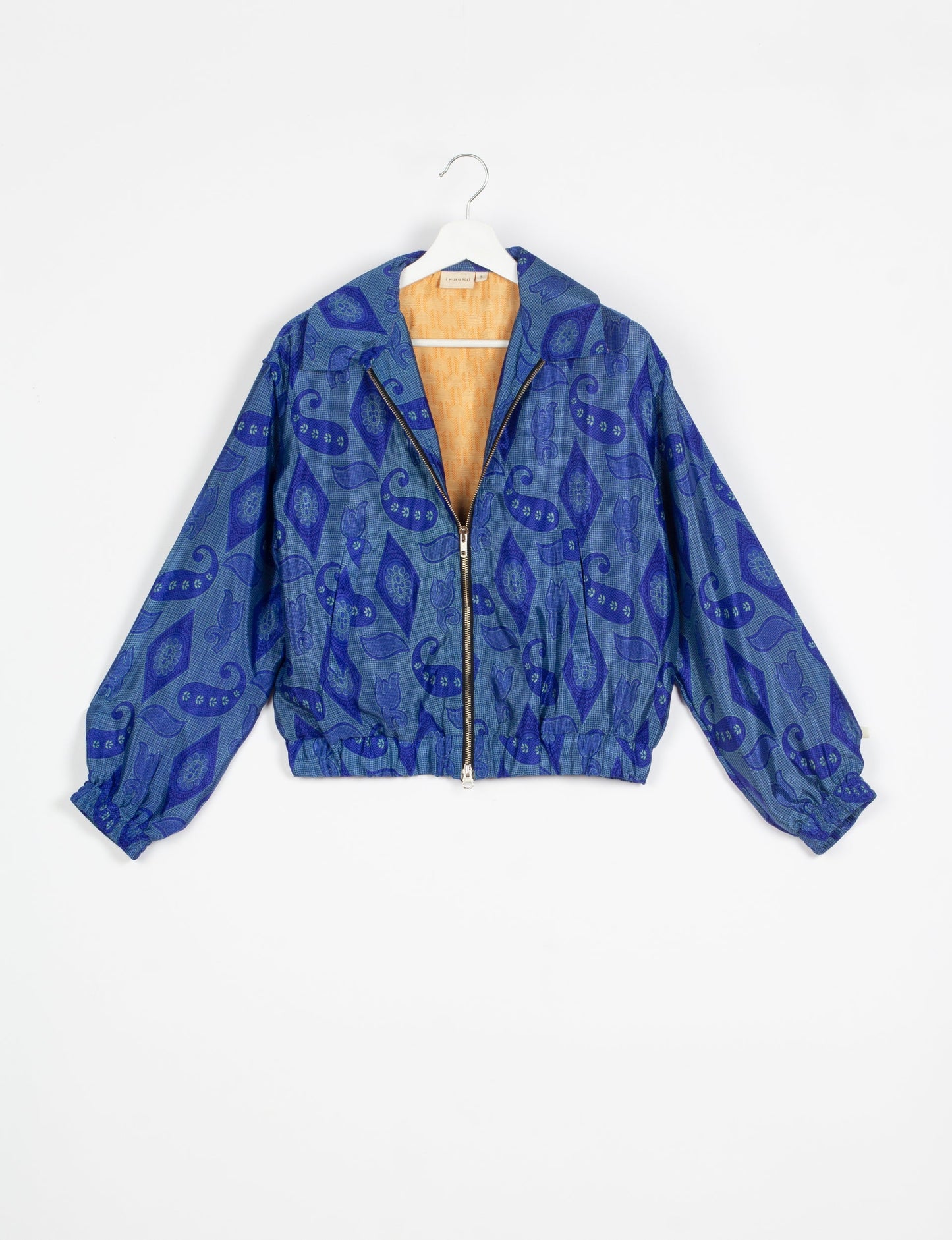 Stylish BOMBER JACKET, an upcycled clothing masterpiece with a cute cropped shape, elasticated details, and detachable metallic zipper. Contrast sari print lining adds a unique touch. Explore sustainable and eco-friendly fashion.