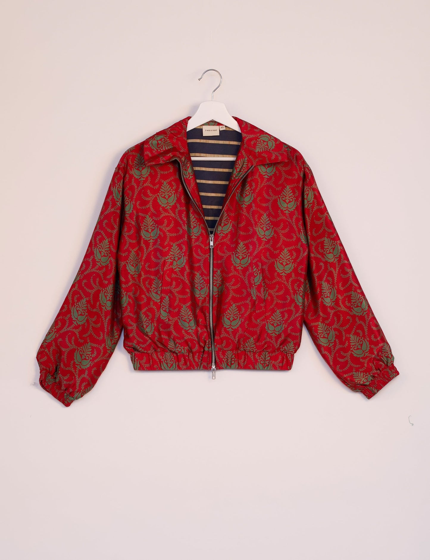 Stylish BOMBER JACKET, an upcycled clothing masterpiece with a cute cropped shape, elasticated details, and detachable metallic zipper. Contrast sari print lining adds a unique touch. Explore sustainable and eco-friendly fashion.