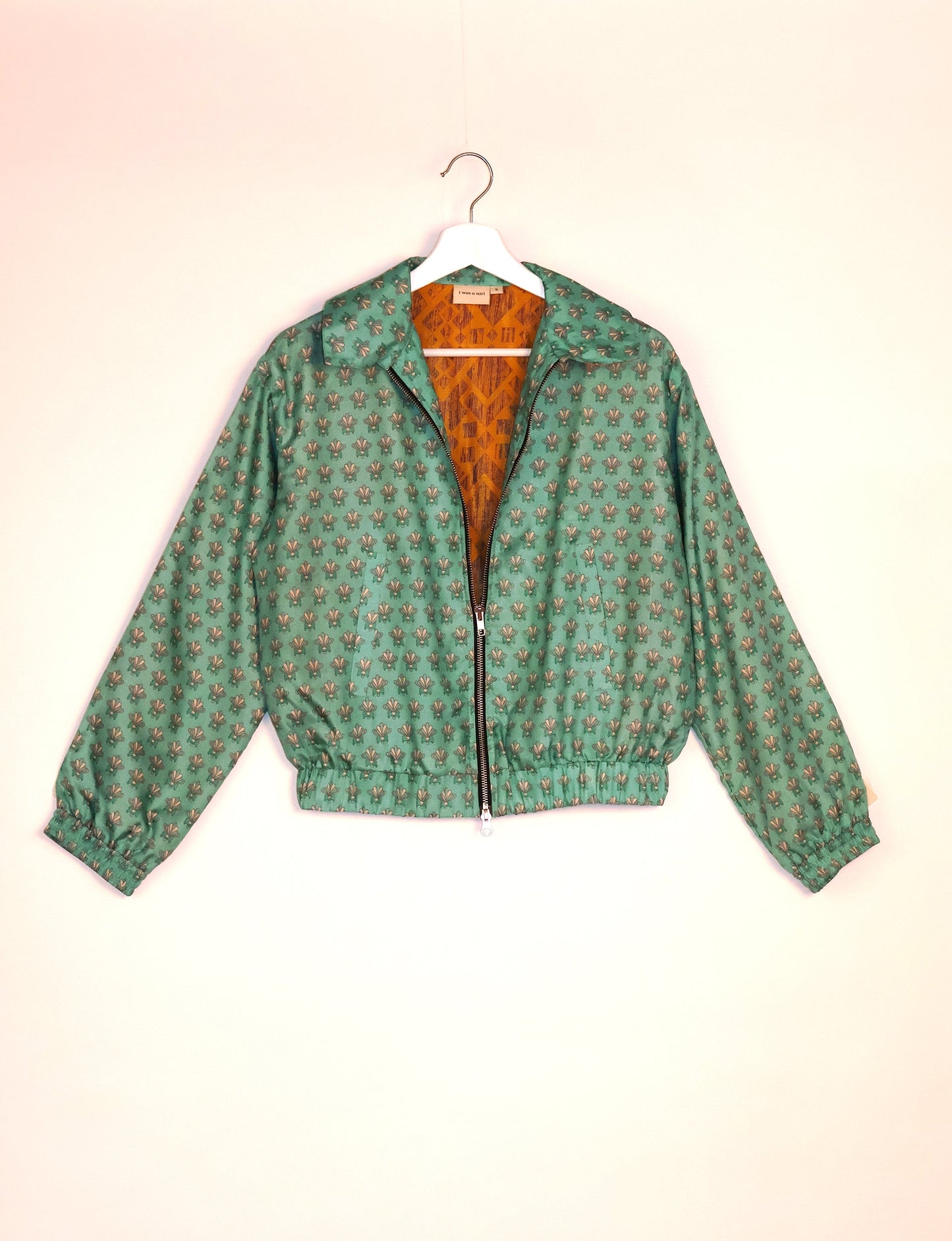 Stylish BOMBER JACKET, an upcycled clothing masterpiece with a cute cropped shape, elasticated details, and detachable metallic zipper. Contrast sari print lining adds a unique touch. Explore sustainable and eco-friendly fashion.