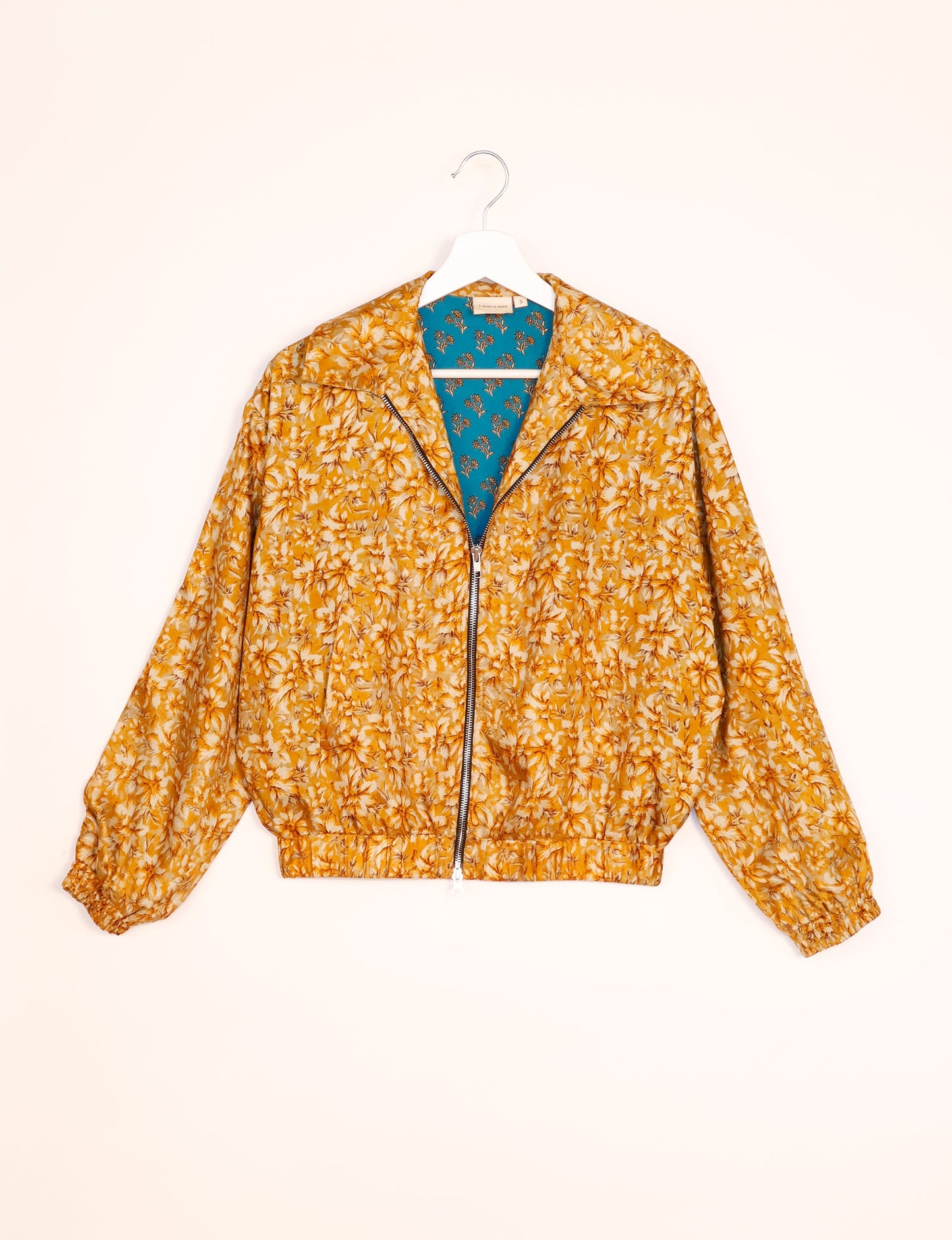 Stylish BOMBER JACKET, an upcycled clothing masterpiece with a cute cropped shape, elasticated details, and detachable metallic zipper. Contrast sari print lining adds a unique touch. Explore sustainable and eco-friendly fashion.