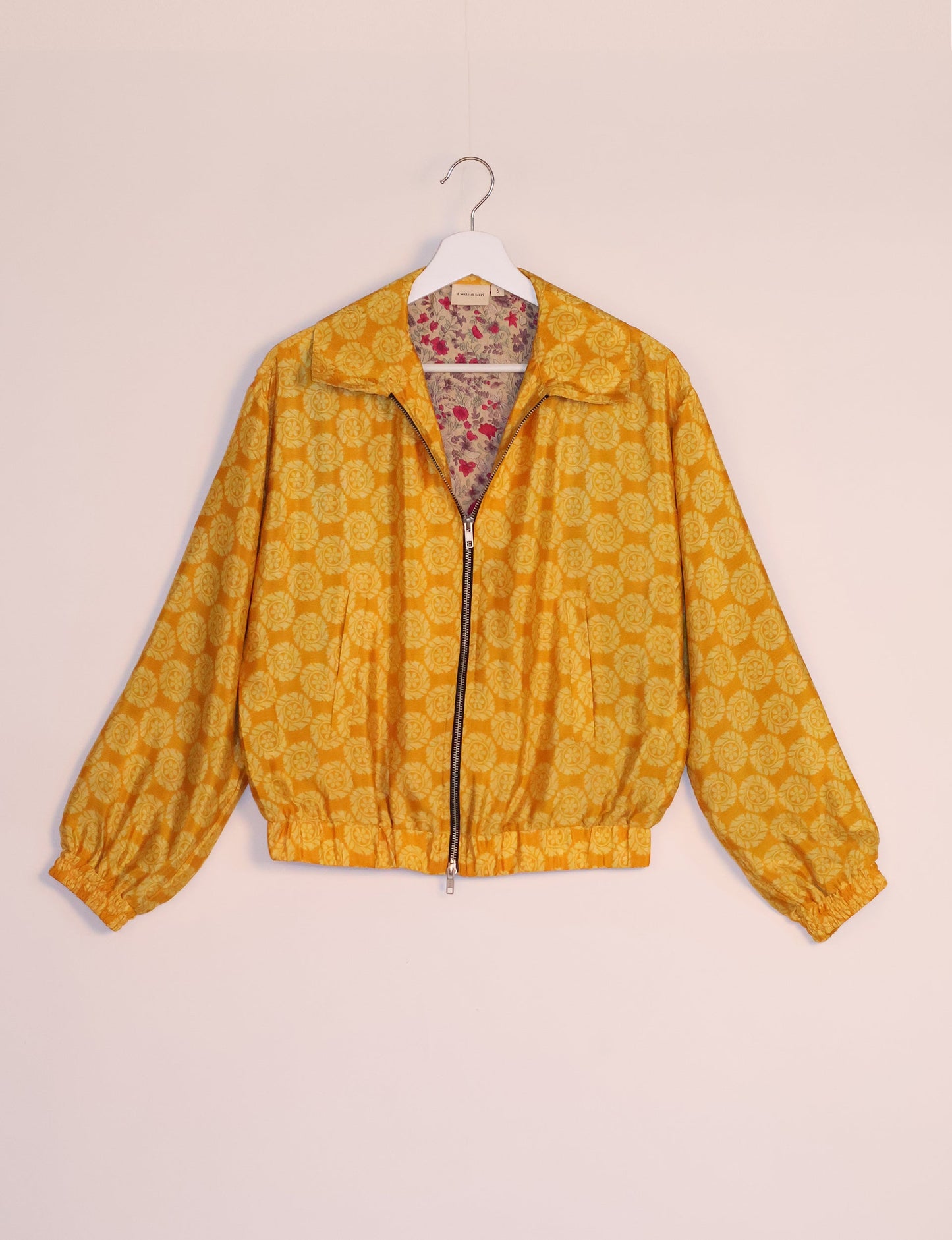 Stylish BOMBER JACKET, an upcycled clothing masterpiece with a cute cropped shape, elasticated details, and detachable metallic zipper. Contrast sari print lining adds a unique touch. Explore sustainable and eco-friendly fashion.