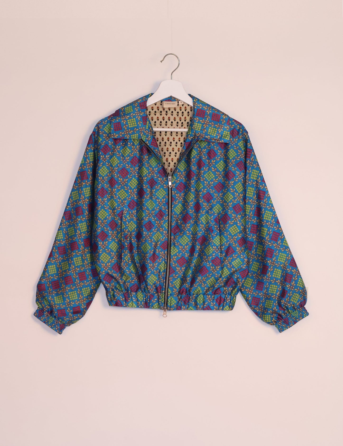 Stylish BOMBER JACKET, an upcycled clothing masterpiece with a cute cropped shape, elasticated details, and detachable metallic zipper. Contrast sari print lining adds a unique touch. Explore sustainable and eco-friendly fashion.