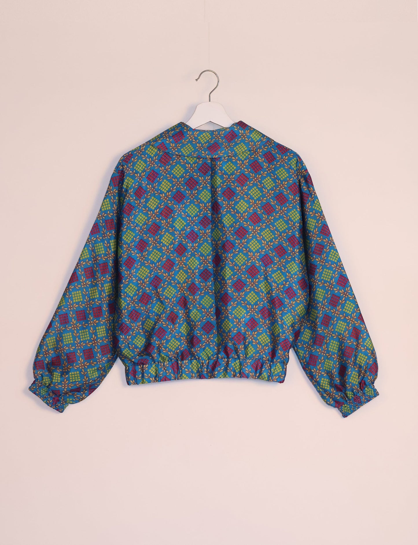 Stylish BOMBER JACKET, an upcycled clothing masterpiece with a cute cropped shape, elasticated details, and detachable metallic zipper. Contrast sari print lining adds a unique touch. Explore sustainable and eco-friendly fashion.