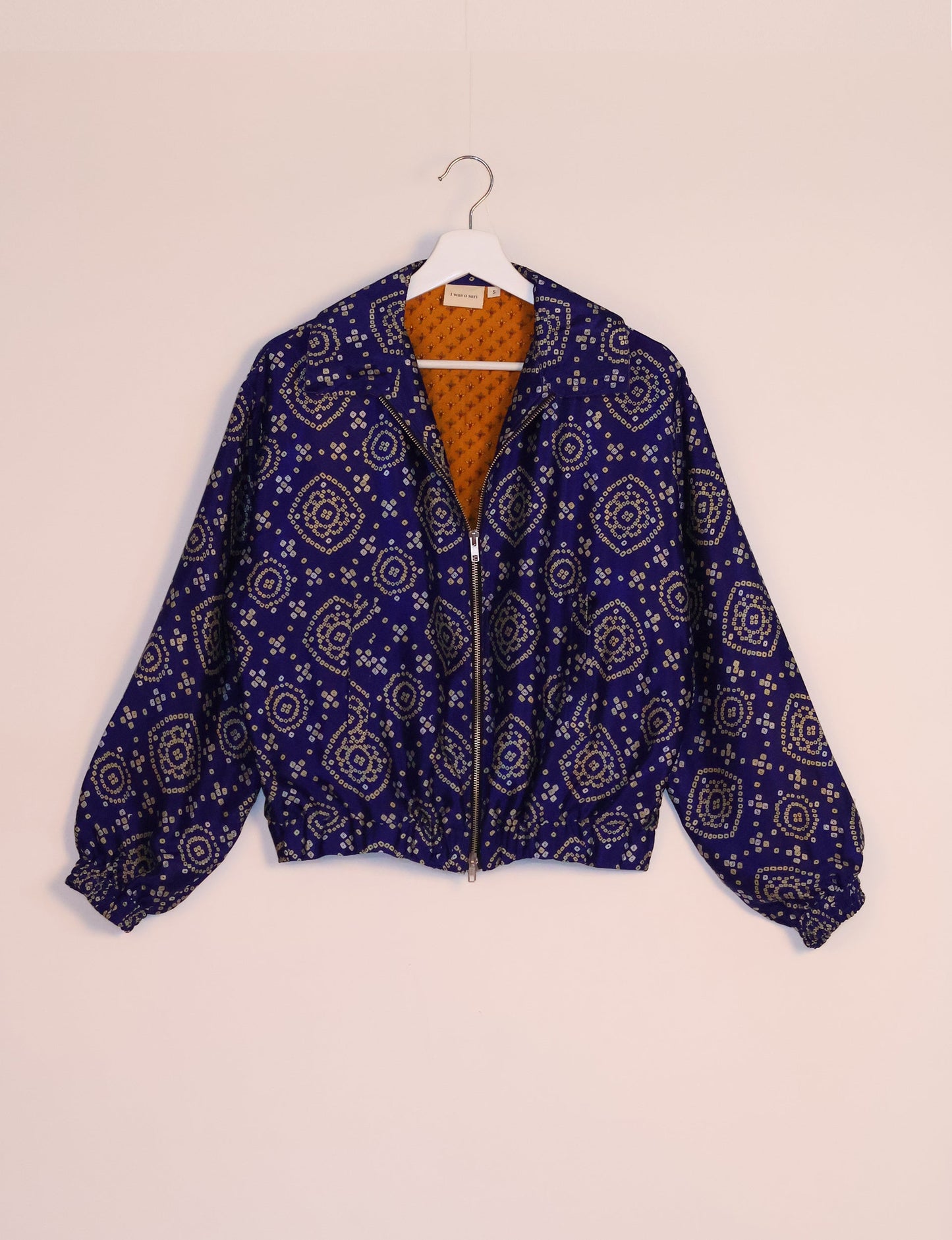 Stylish BOMBER JACKET, an upcycled clothing masterpiece with a cute cropped shape, elasticated details, and detachable metallic zipper. Contrast sari print lining adds a unique touch. Explore sustainable and eco-friendly fashion.