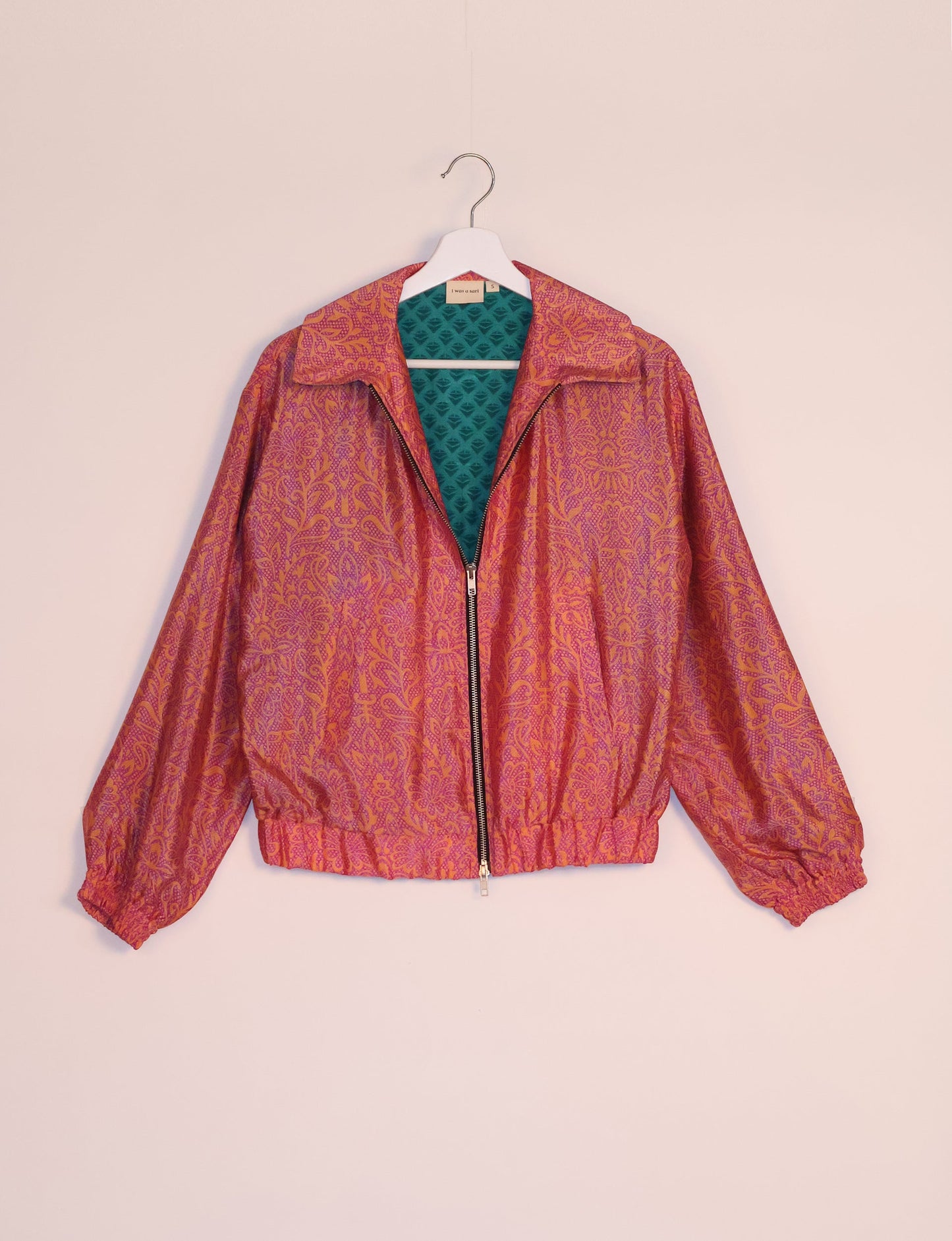 Stylish BOMBER JACKET, an upcycled clothing masterpiece with a cute cropped shape, elasticated details, and detachable metallic zipper. Contrast sari print lining adds a unique touch. Explore sustainable and eco-friendly fashion.