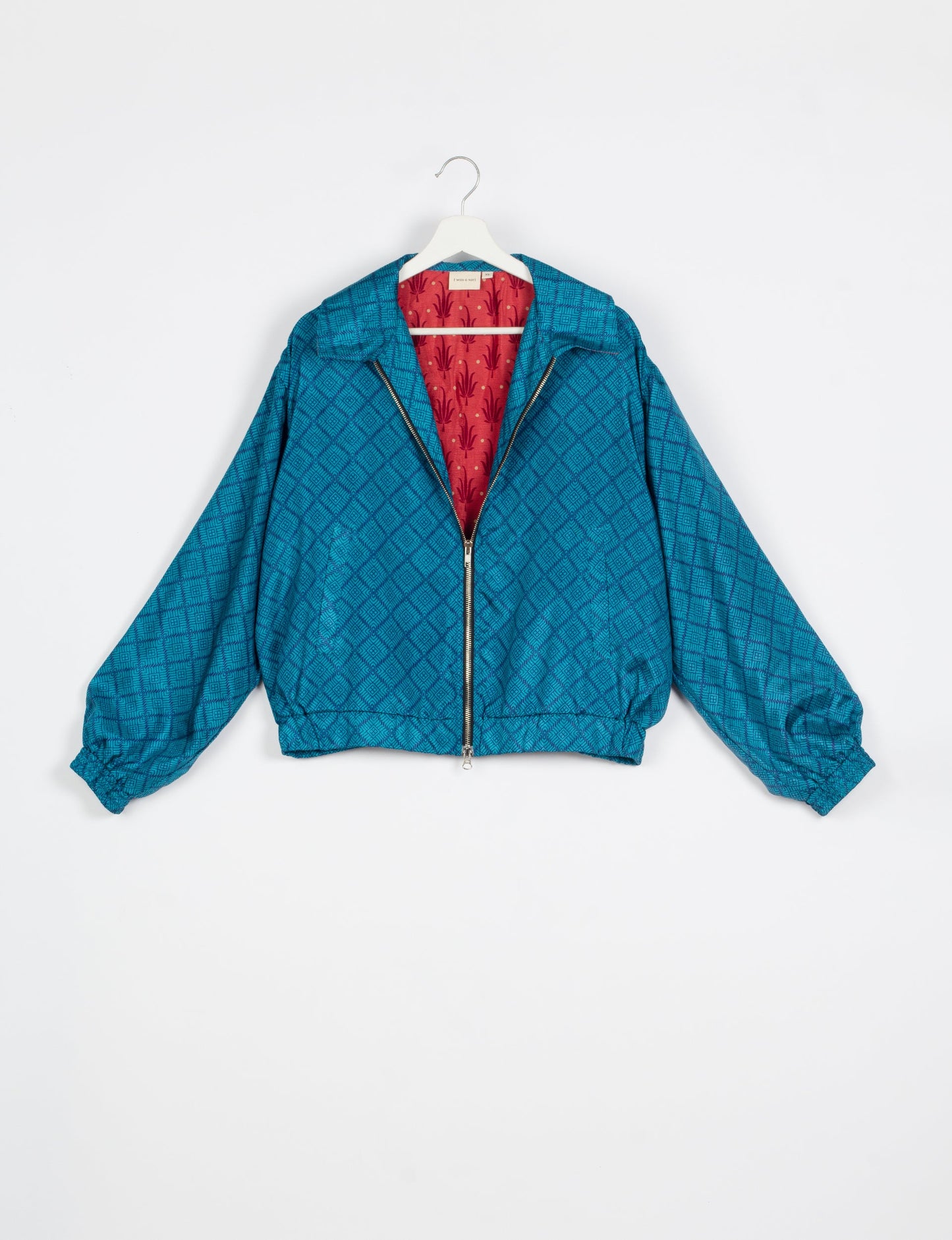 Stylish BOMBER JACKET, an upcycled clothing masterpiece with a cute cropped shape, elasticated details, and detachable metallic zipper. Contrast sari print lining adds a unique touch. Explore sustainable and eco-friendly fashion.